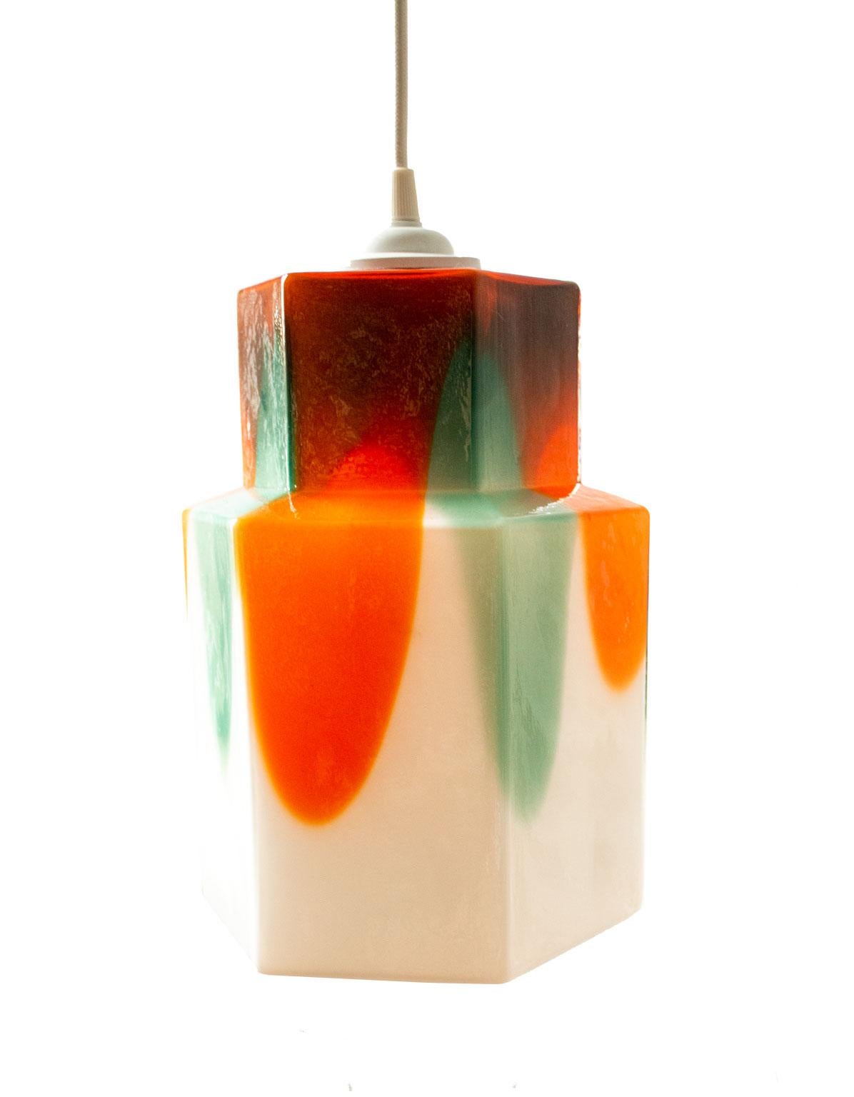 Scandinavian modern glass pendant by Helena Tynell, 1960s. A hexagonal glass pendant designed by Helena Tynell for Flygsfors, Sweden, 1960s. A large tiered body of white handblown glass with painterly streaks of red, orange and turquoise emphasizing