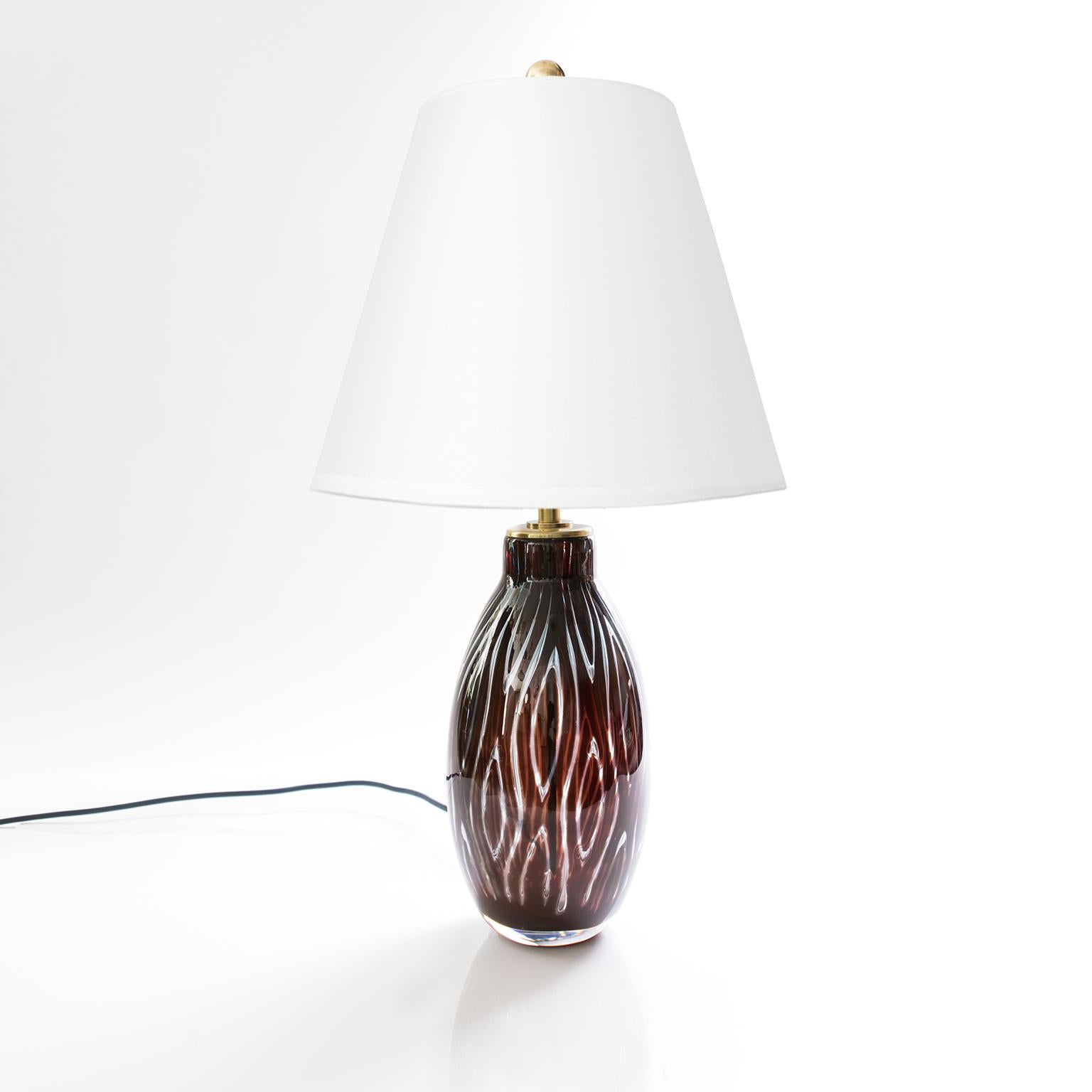 A Scandinavian Modern glass table lamp by Swedish designer Edvin Ohrstrom for Orrefors. The lamp was made using the 