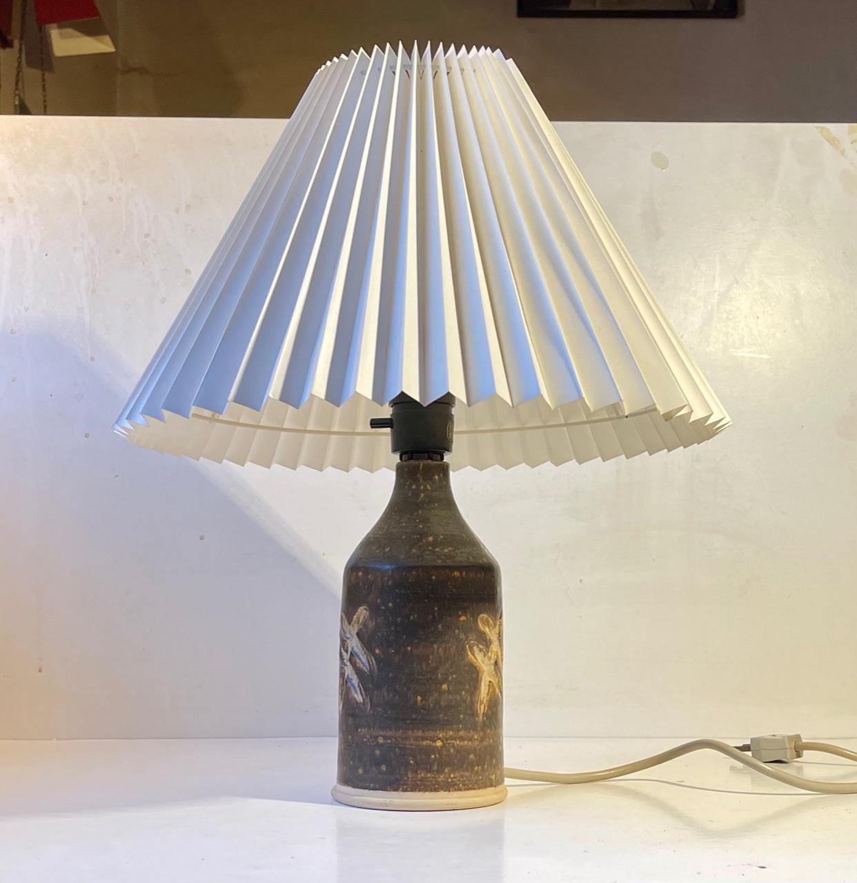 Stoneware table lamp by the Danish ceramist Per Engstrom. It is executed in stoneware glazed in an earthy brown color with lots of play. It features abstract incised and glazed symbols to each side. I has its original socket with on/off switch