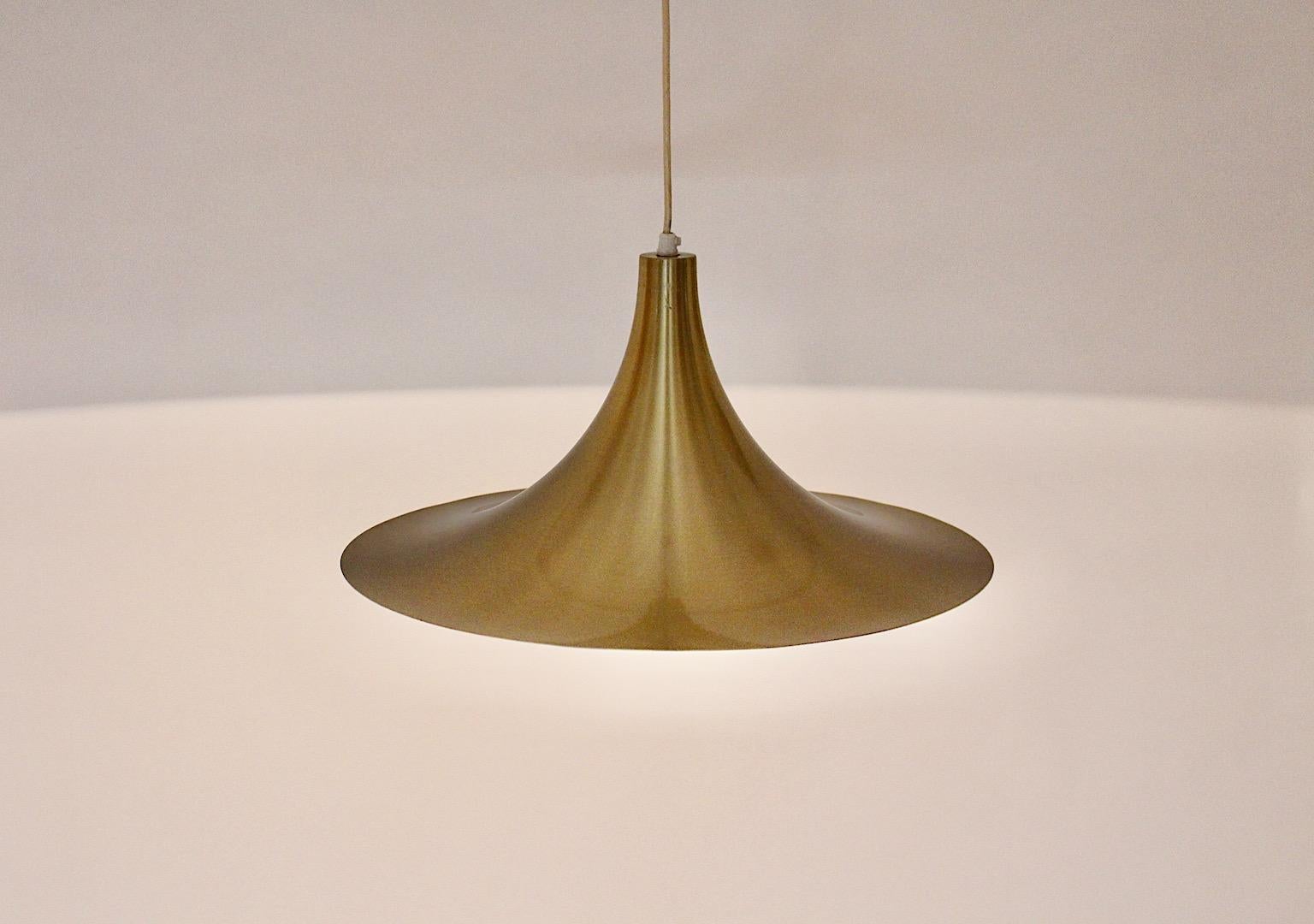 Scandinavian Modern vintage semi pendant from golden aluminum in trumpet like shape 1980s.
A stunning new arrival, the semi pendant in golden color from aluminum.
The pendant shows one E 27 socket, max. 100 W,  and white color inside. Through the