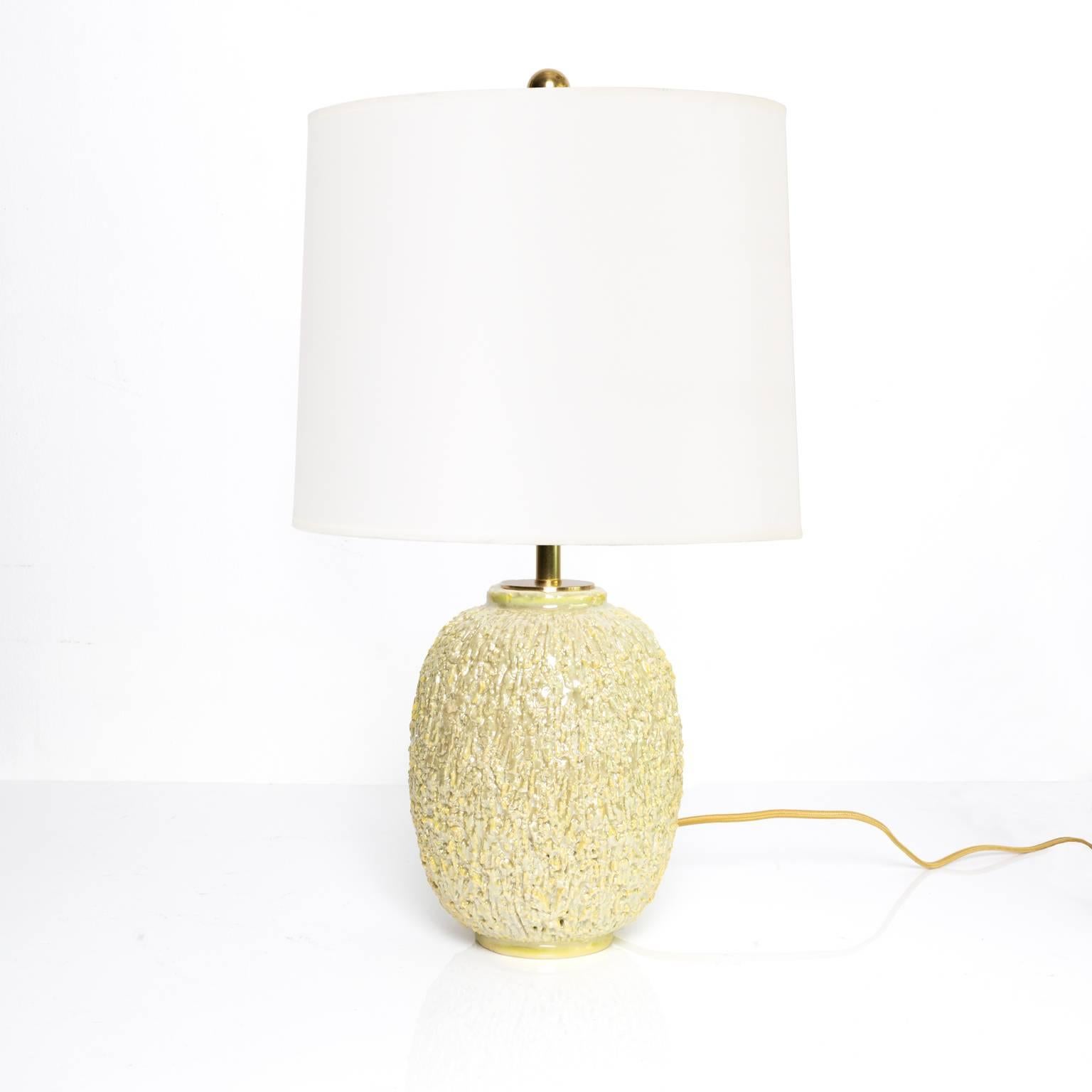 A highly textured surface Scandinavian Modern ceramic lamp by Gunnar Nylund for Rörstrand, Sweden. The lamp is made of chamotte clay and finished with a cream colored luster glaze. New all brass hardware including a double standard bulb socket
