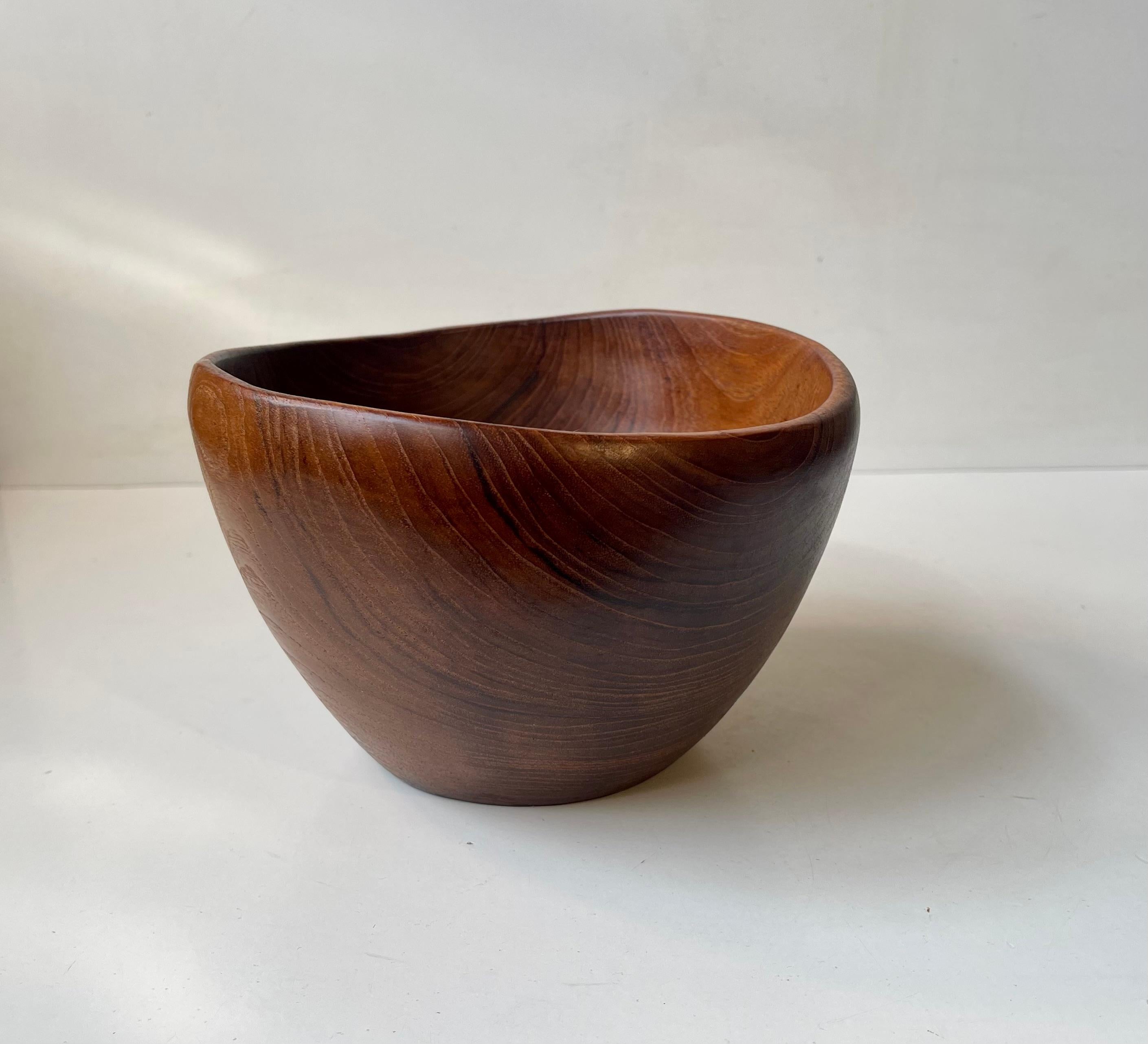 Unusual asymmetrical bowl in solid teak. Beautiful hand-finished organic shape with soft curves. Suitable as decorative centerpiece, for fruits or salad. It was made in-house at ESA Møbler in Denmark during the 1950s in a style reminiscent of Finn