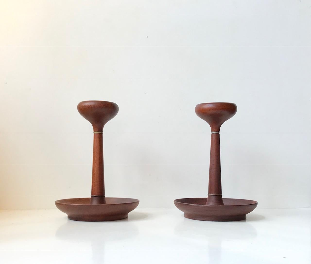 A pair of organically shaped candlesticks with original deep rich patina to hand-turned teak wood. Anonymous Scandinavian design/maker, circa 1960 in the style of rude Osolnik and Illums Bolighus. Both of them marked with a rosewood button to the