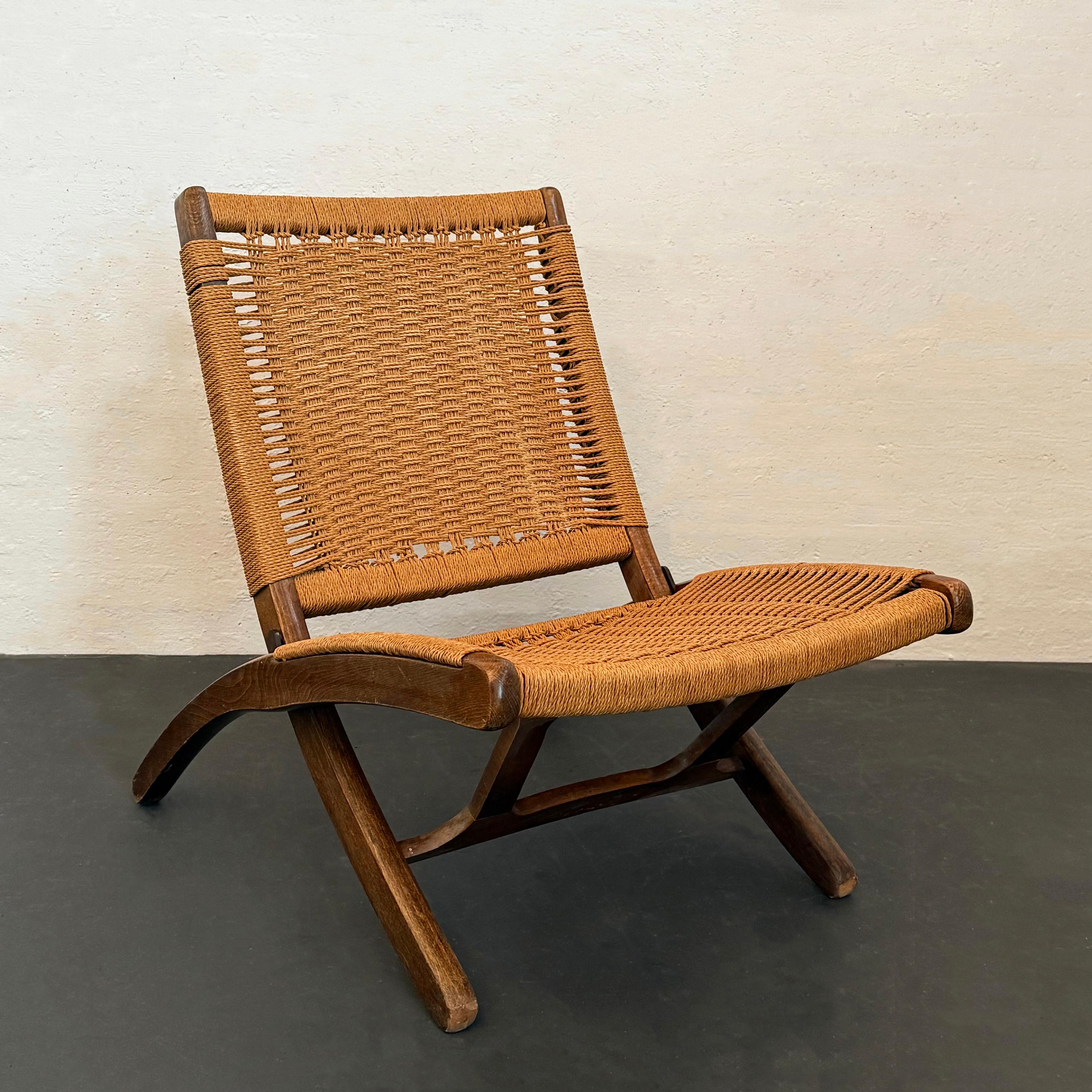 This Scandinavian design folding rope chair captures the style of Hans Wegner without a hefty price tag. Made in Yugoslavia in the mid 20th century, it features a sturdy solid beech wood frame with a woven rope backrest and seat. It easily folds in