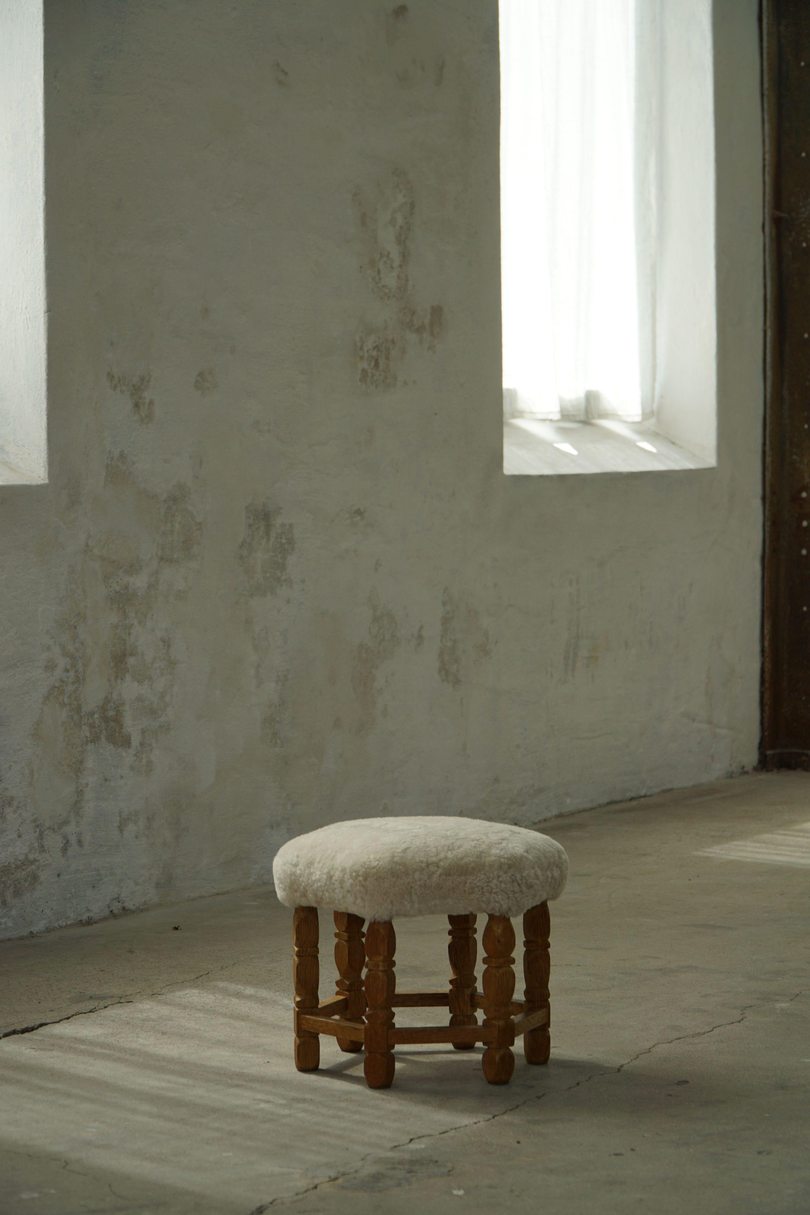 A Danish modern stool in oak, featuring distinctive curly legs and a hexagonal seat newly upholstered in high-quality light cream lambswool. Crafted by a Danish cabinetmaker in the 1950s, this fine piece presents a refined yet inviting aesthetic.