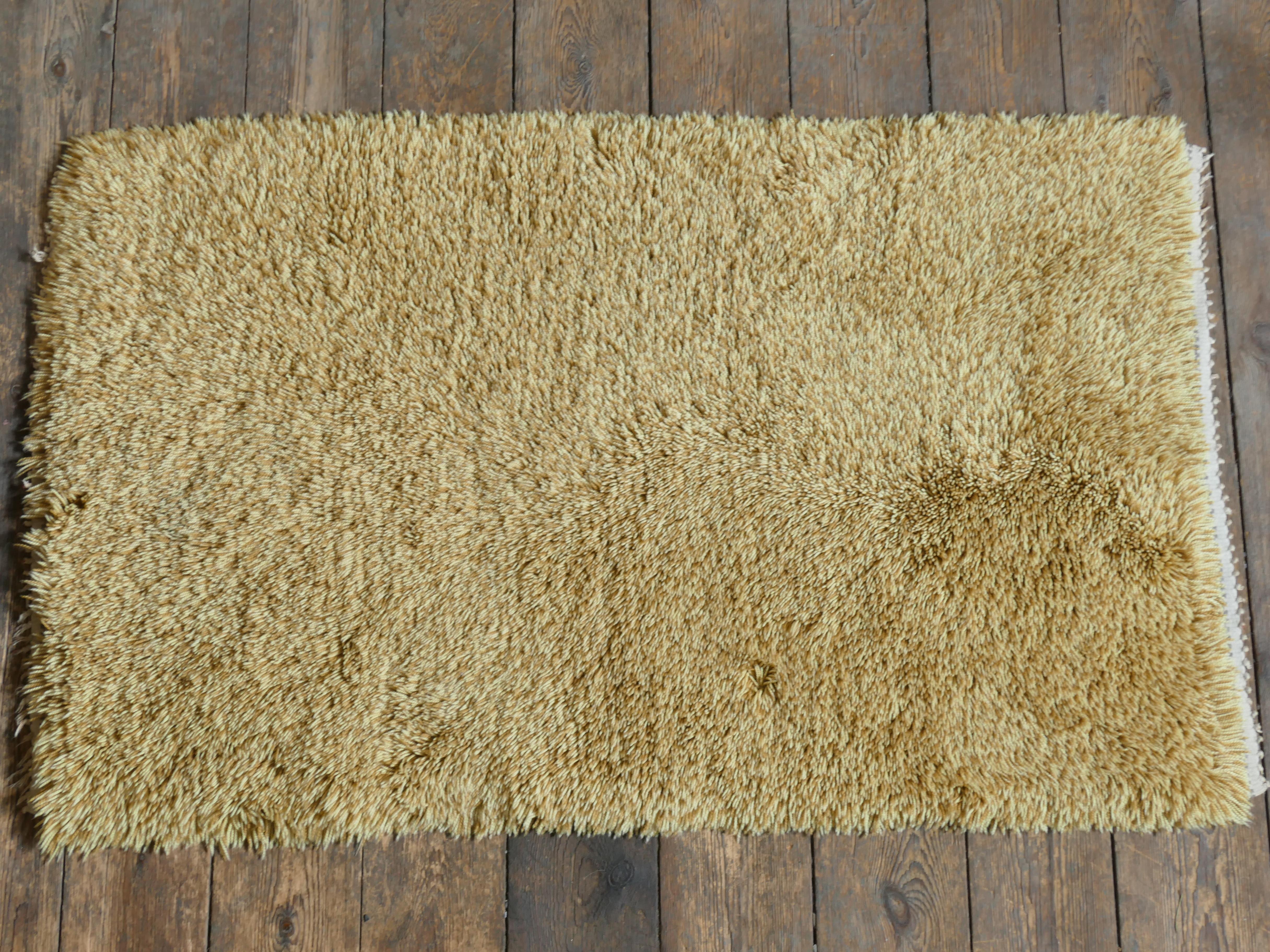 Ce tapis The Modern Scandinavian Scandinavian en laine à poils hauts présente des tons doux et vifs de jaune paille, qui apportent une élégance calme à cette pièce. Le fil est noué en utilisant deux teintes de jaune différentes dans le même nœud, ce