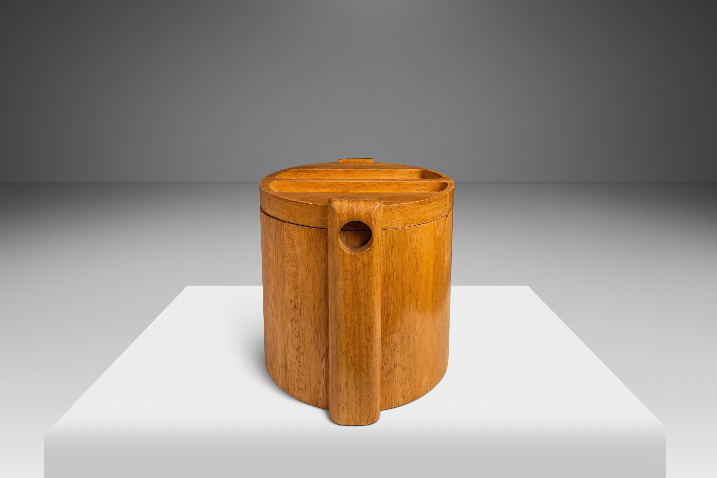 Introducing a beautifully crafted Ice Bucket produced by the ROYAL TEAK Company in the 1970's. The exterior, made entirely from solid Burmese teak, features a rare blonde treatment that sets this teak ice bucket apart from others constructed from