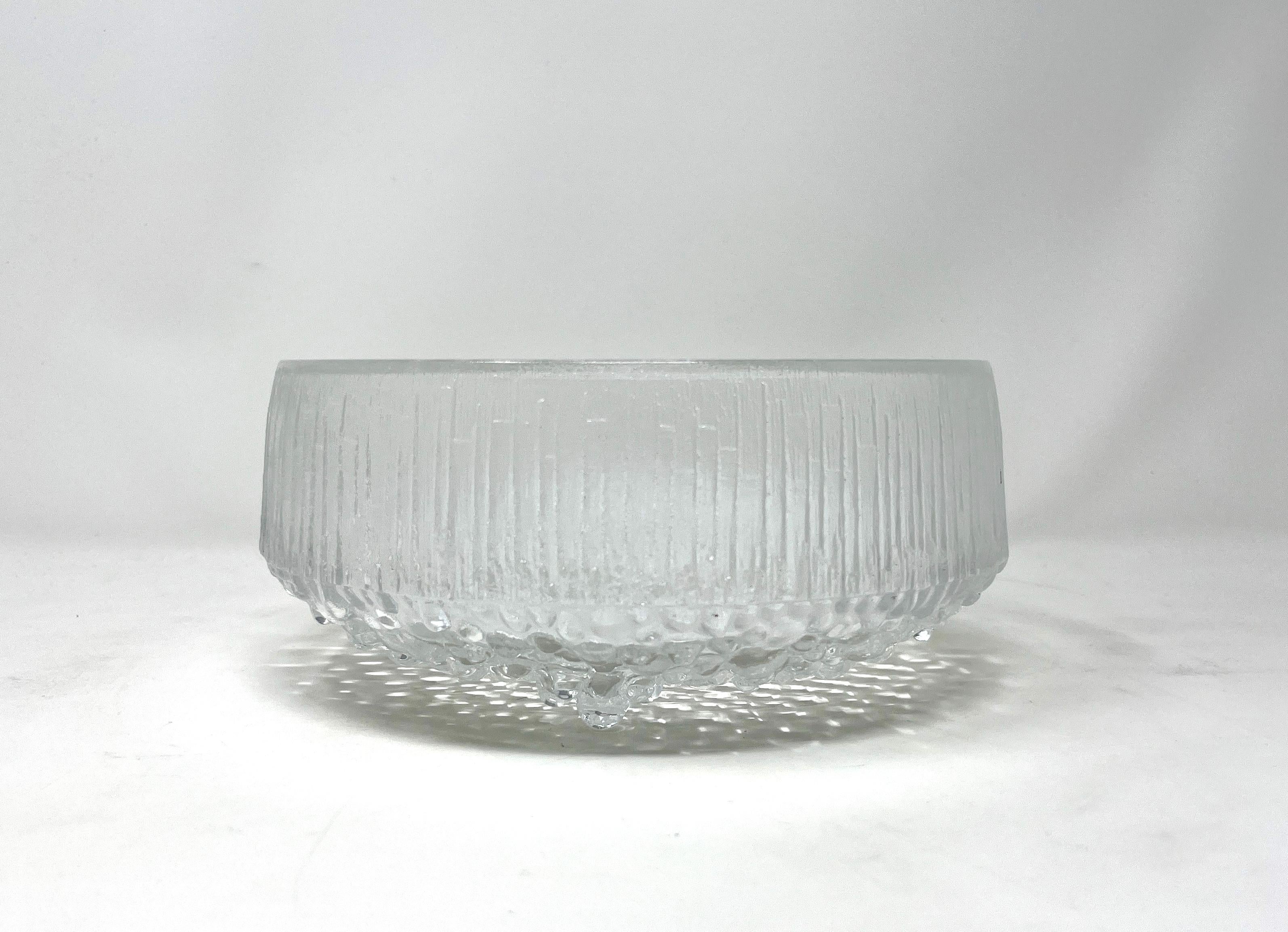 Frutero grande de cristal escandinavo moderno Iittala de Tapio Wirkkala para Iittala en la línea Ultima Thule. El cuenco con pie tiene los lados texturizados, que hacen referencia al terreno helado del norte de Escandinavia. Este bol grande para