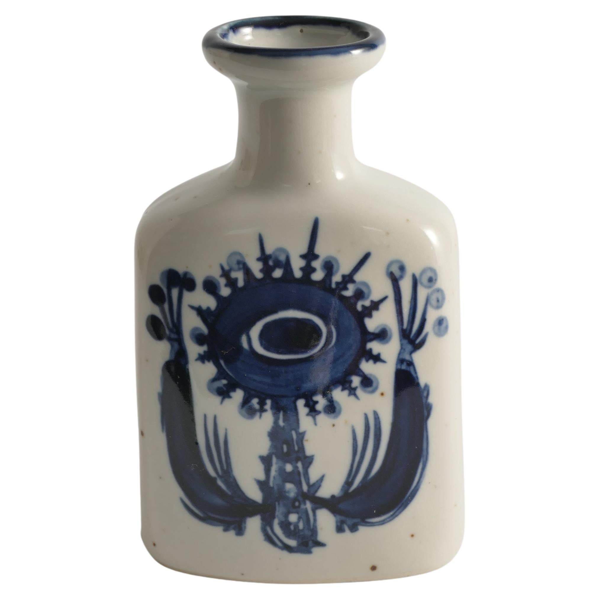 This Scandinavian modern indigo blue flower motif stoneware vase, attributed to Berte Jessen of Royal Copenhagen, is a beautifully crafted piece featuring hand-painted indigo blue motifs on each side. The design depicts both large and small fantasy
