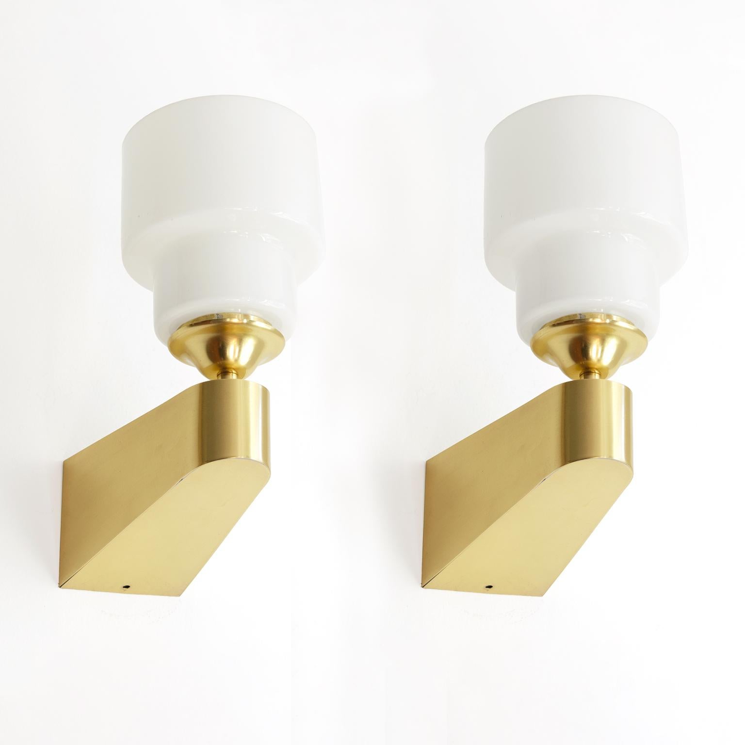 Pair of Itsu, wedge shaped polished brass with opal glass shades with a stepped shape. The sconces have been newly rewired with single standard base sockets for us in the USA. The brass has been newly polished and lacquered. Very good condition with