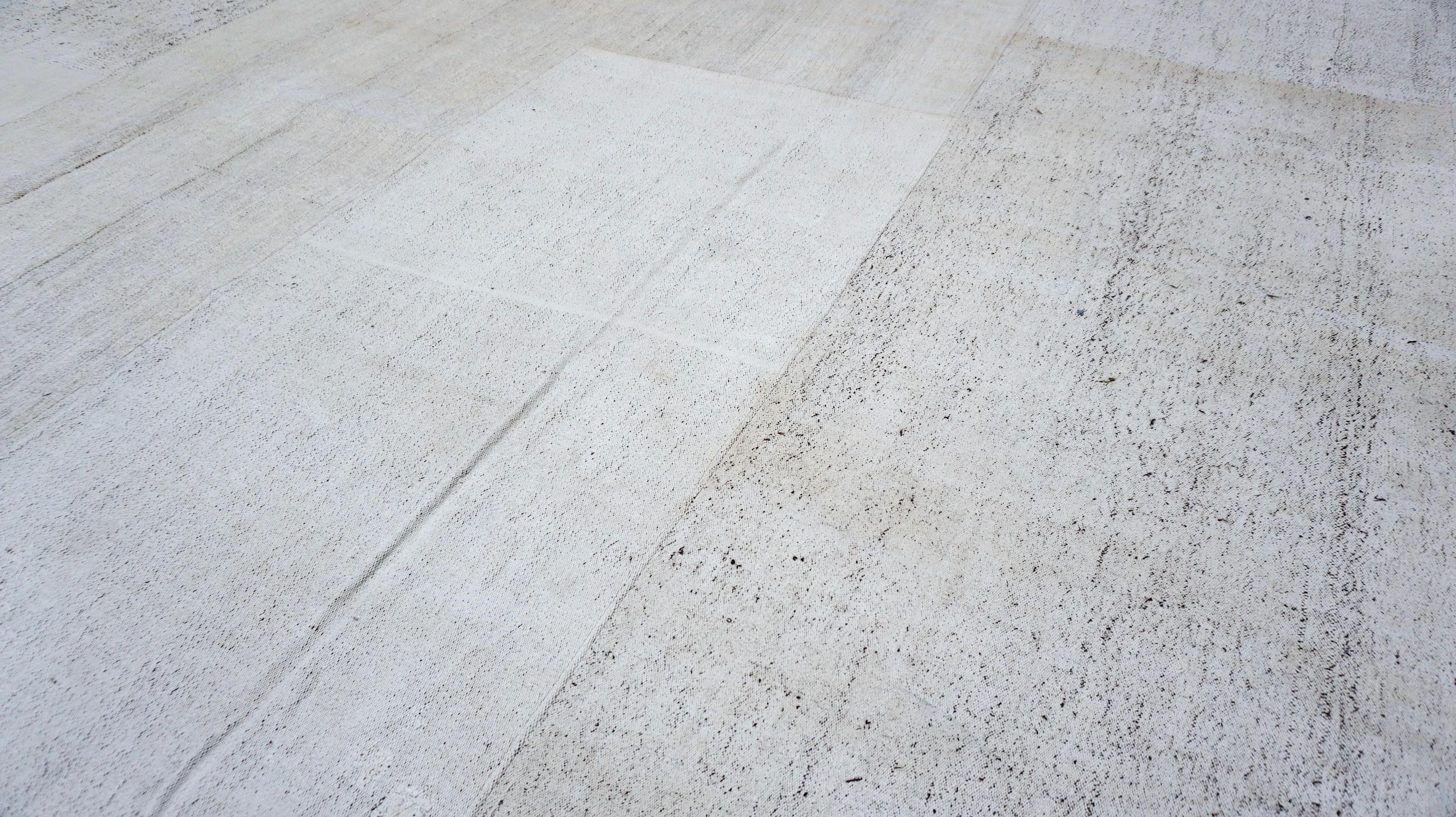 This hand-woven rug seamlessly blends natural fibers and contemporary minimalism. Crafted from a durable mix of wool and hemp, this piece features a patchwork construction made from vintage kilim fragments, unified under a refined pale gray and