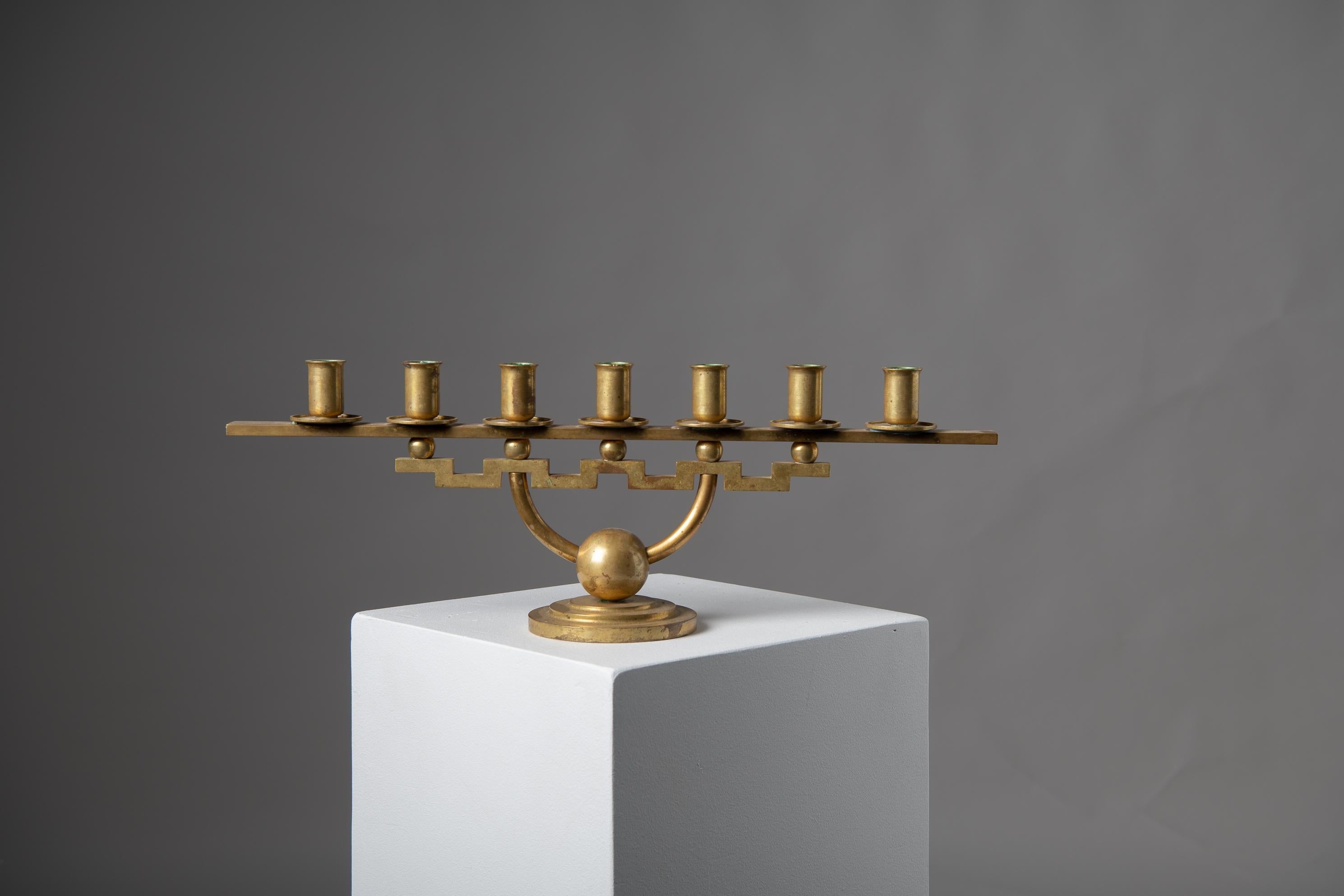 Moderner skandinavischer Kerzenständer von Lars Holmström, Arvika Schweden. Der Kerzenhalter hat sieben Arme und zeichnet sich durch ein geometrisches, aber einfaches Design aus. Sie ist aus Messing gefertigt und hat die authentische Patina der