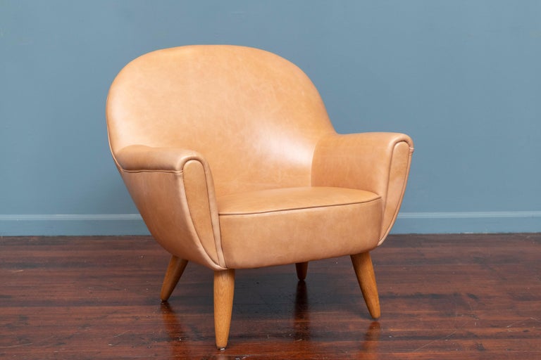 Scandinavian Modern lounge chair newly upholstered in high quality Maharam leather on refinished oak legs. Quirky shaped chair body that is oddly appealing and very comfortable to sit in, ready to be enjoyed for years and years to come.