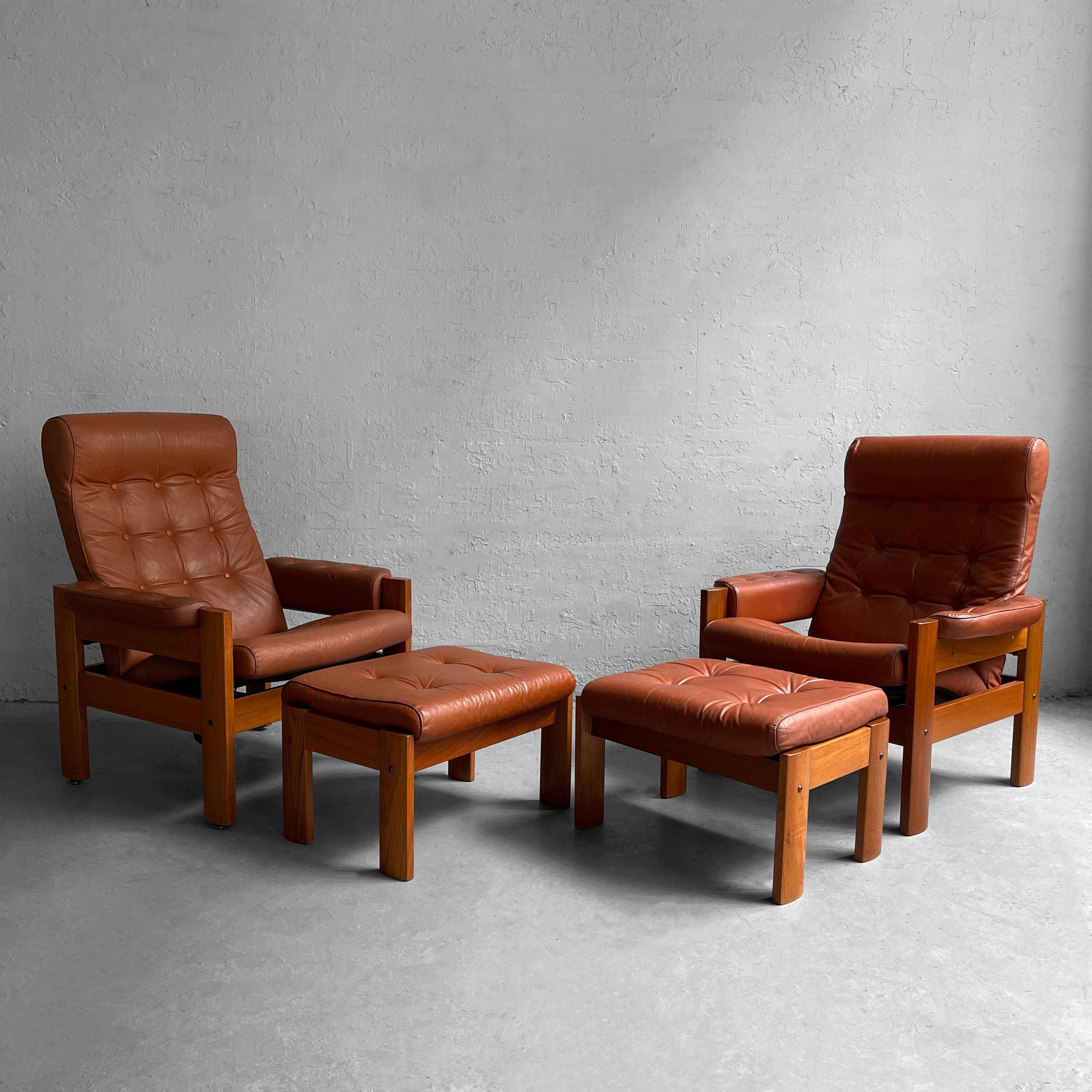 Pair of high back, Scandinavian modern, stressless recliners with matching ottomans, made in Norway by Ekornes feature teak frames with button tufted, lugguage tan leather upholstery. The chairs maneuver easily from upright to almost flat. The