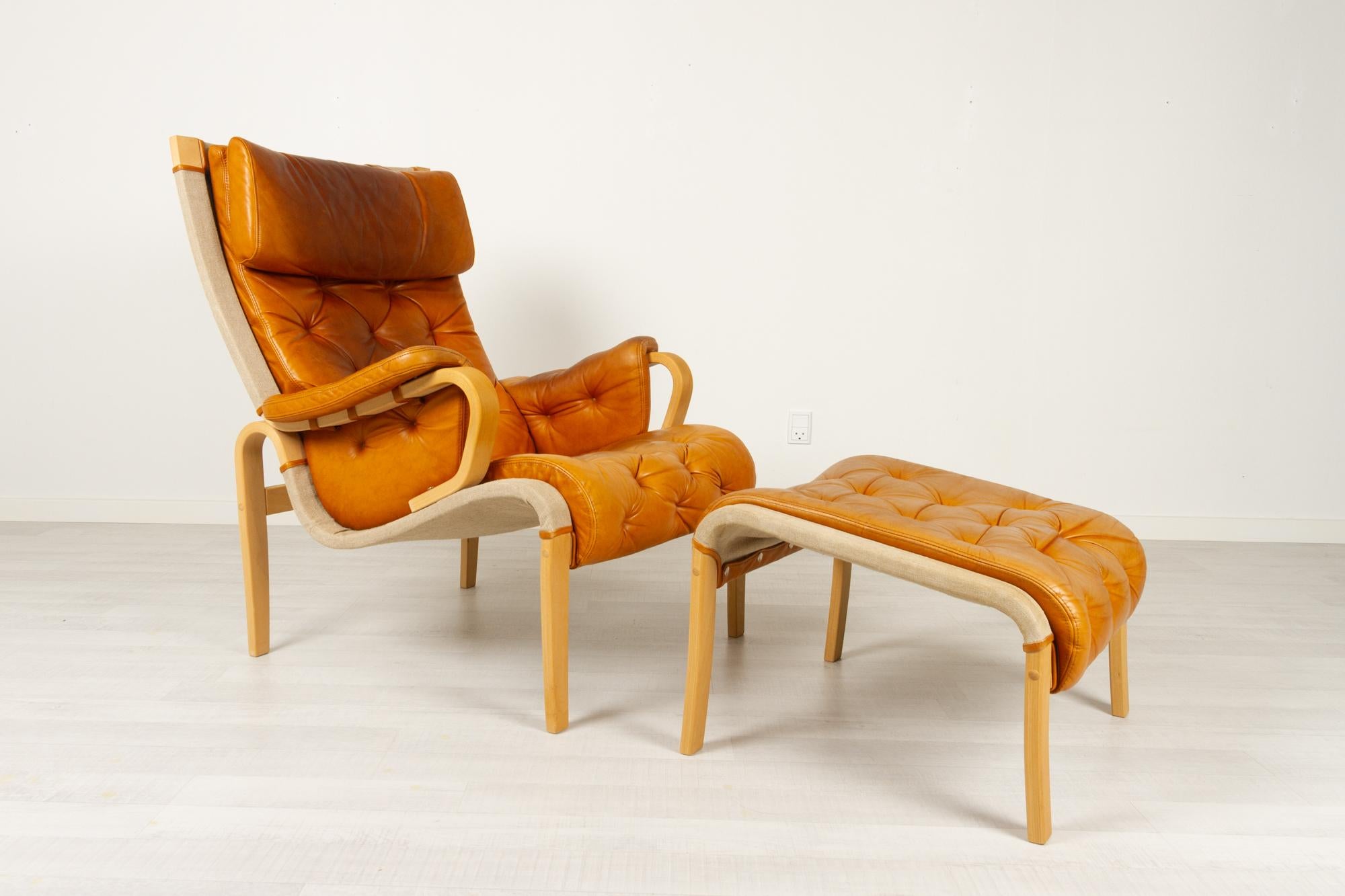 Scandinavian Modern lounge chair and stool by Nielaus & Jeki Møbler 1980s
Stylish and elegant Danish lounge chair with matching footstool in bent laminated beech with very soft cognac colored leather upholstery. 
This chair has many similarities