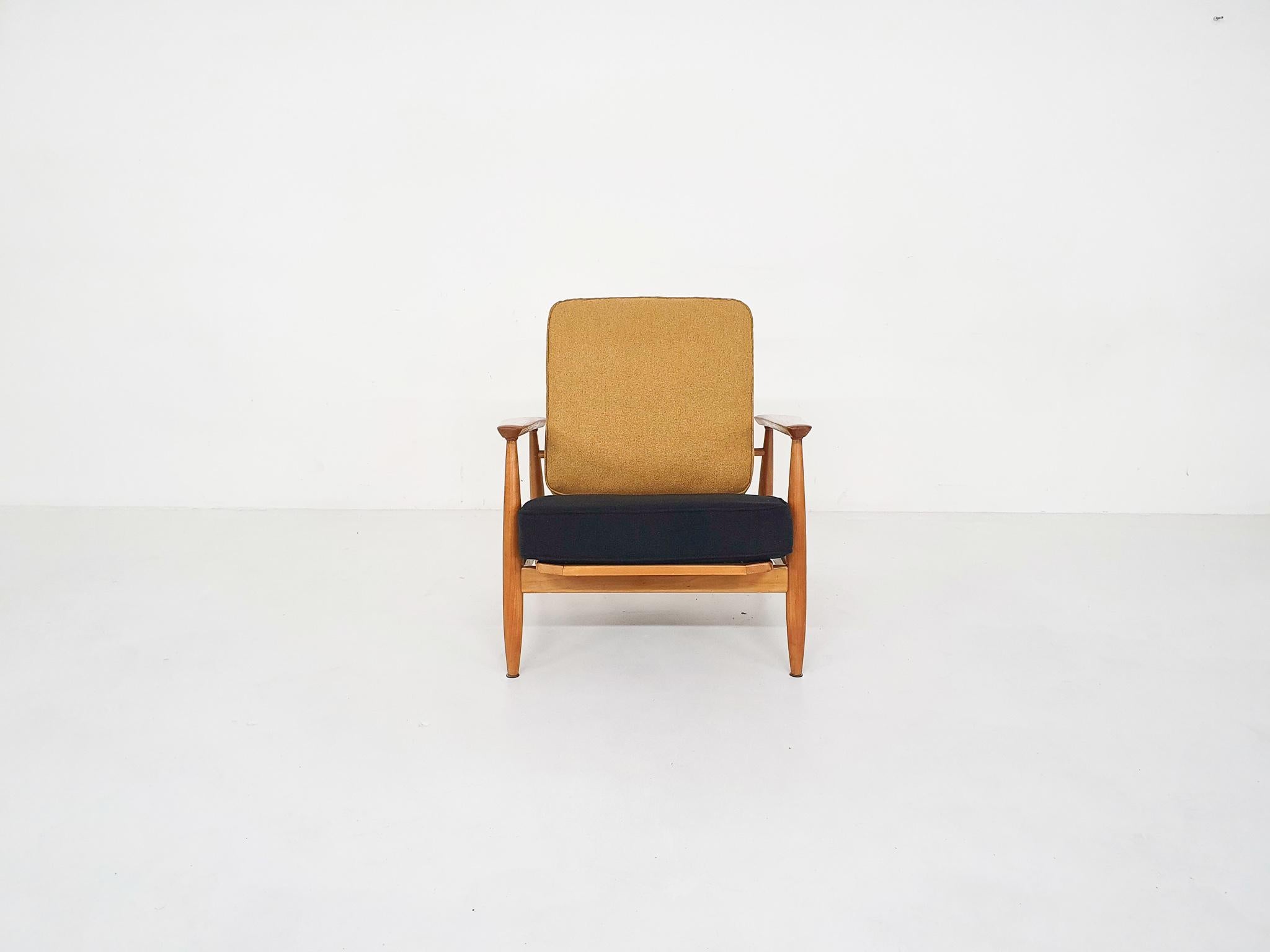 Scandinavian Modern spindle back lounge chair with arm rests from the 1960s.

The designer is yet unknown, but the design remind us of the Domus 1 lounge chair by Alf Svensson for DUX. We re-upholstered the cushions in black and ochre. The frame