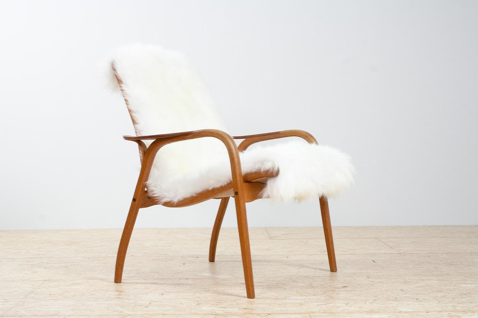New upholstered Scandinavian modern Lamino chair, ladies' version with a lower back. Re-upholstered with a very high quality long haired sheep skin. This 'ladies' version has a lower back with delicately splayed legs, and elegant flared armrests.