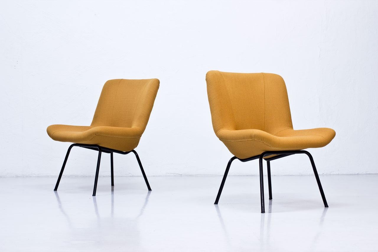 Rare pair of Scandinavian Modern lounge chairs, model “Lehti” (leaf) designed by Carl Gustaf Hiort af Ornäs. Manufactured by Puunveisto Oy - Träsnideri in Finland during the 1950s. 
The chairs are made from black lacquered tubular metal base. Seats