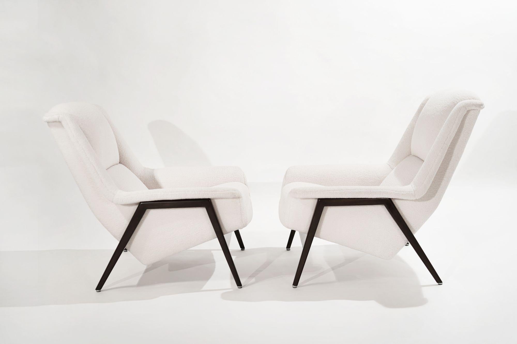 Stunning pair of large profile Scandinavian-Modern lounge chairs designed by Folke Ohlsson for DUX of Sweden, circa 1960s.
 
Signature teak frames have been fully restored and ebonized rendering the perfect contrast to their new off-white wool