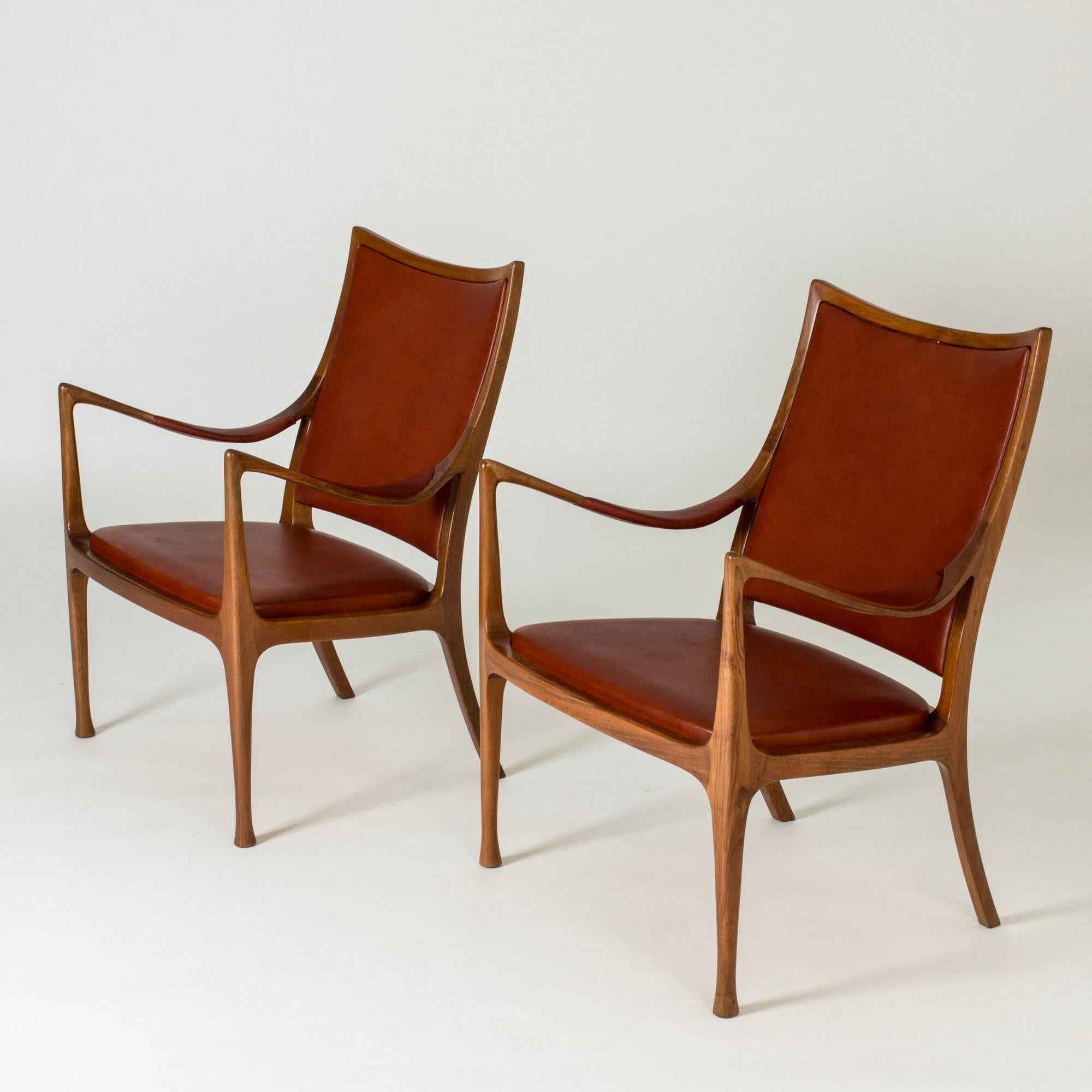 Pair of amazing lounge chairs by Hans Asplund, made in mahogany with leather seats and backs, and a leather detail on the armrests. Striking silhouettes, exquisite execution.

The chairs were custom made for the beauty lounge in the NK department