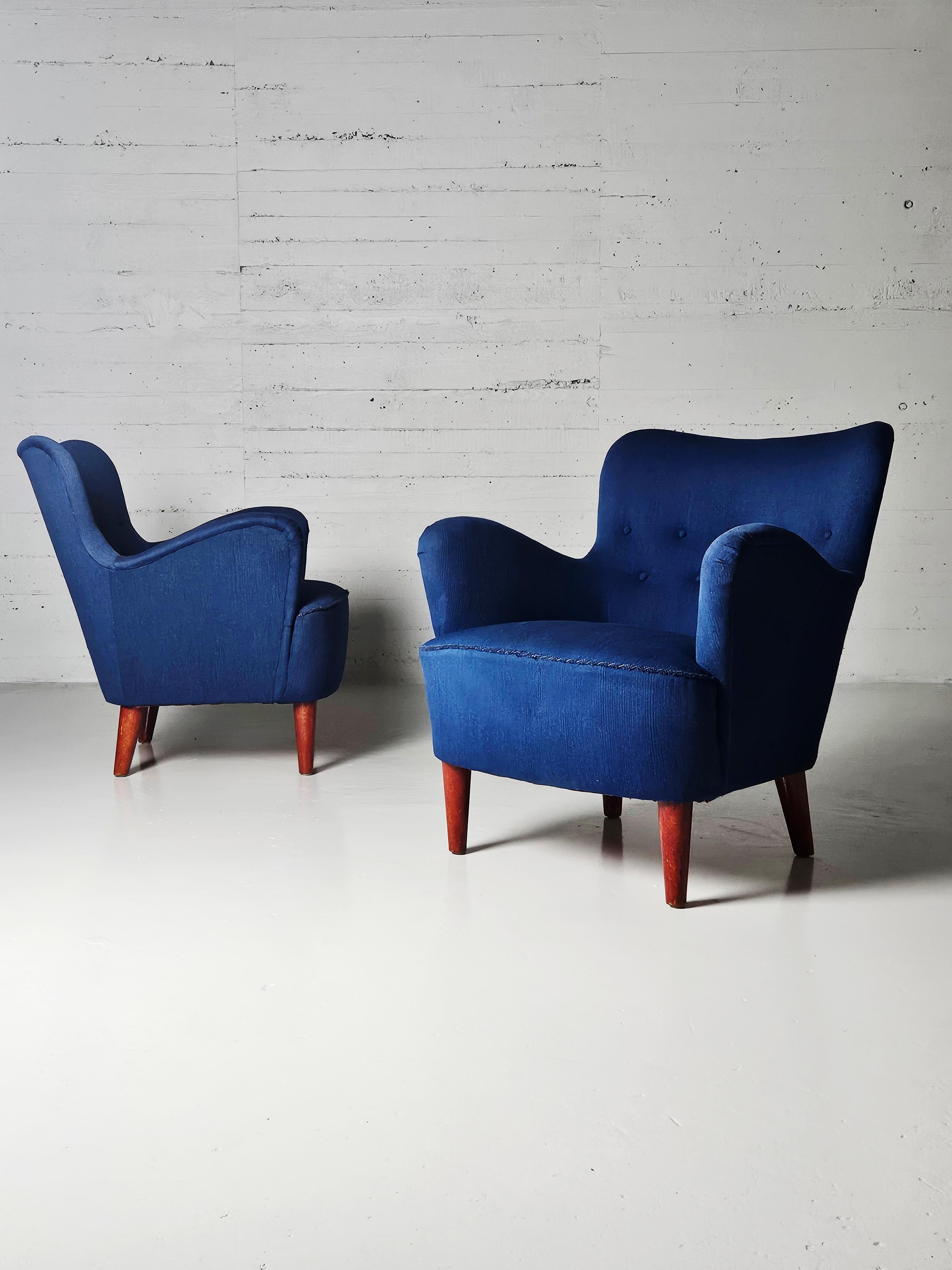 Swedish modern armchairs by anonymous designer from the 1960s. 

Legs of stained beech and upholstered in a beautiful blue fabric. Generous armrests.