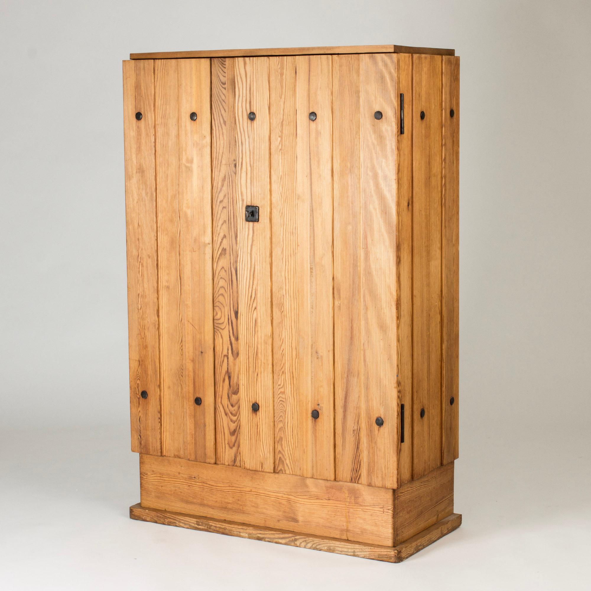 Lovö” cabinet by Axel Einar Hjorth, made from solid pine in a striking, rustic design. Wrought iron details and lock. Practical drawers and shelves inside.