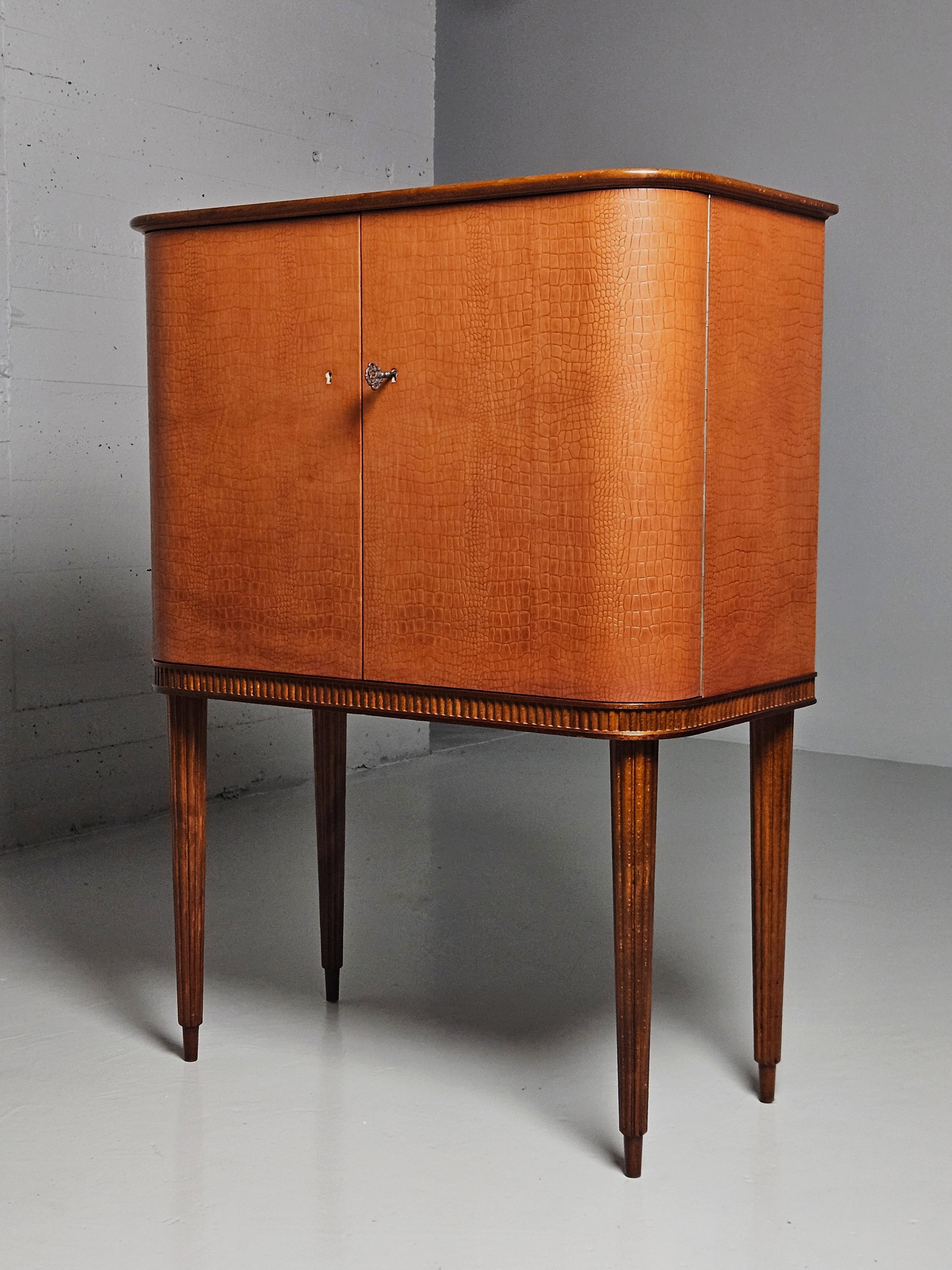 Great bar cabinet by unknown Swedish designer. Produced by AB Förenade Möbelfabrikerna Linköping, Sweden, during the 1950s. 

Made in mahogany with a leather dressed front. Slender sculptural legs. Mirror glass and lighting. 