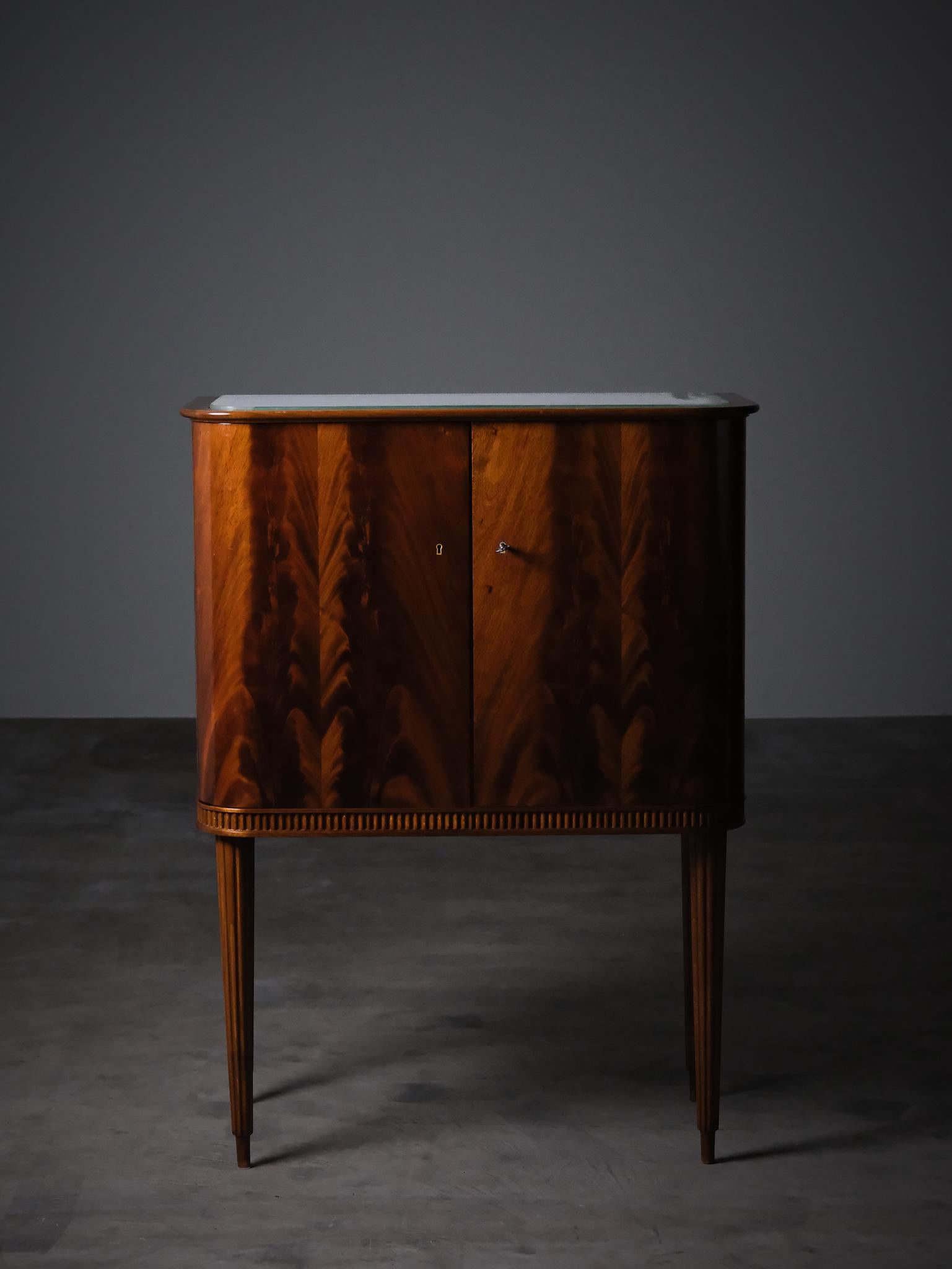 Elegante mobile bar svedese, progettato negli anni '50 e prodotto da AB Förenade Möbelfabrikerna a Linköping.

Realizzato in ricco mogano con linee pulite e moderniste e gambe sottili e scolpite. Gli interni sono caratterizzati da vetri a specchio e