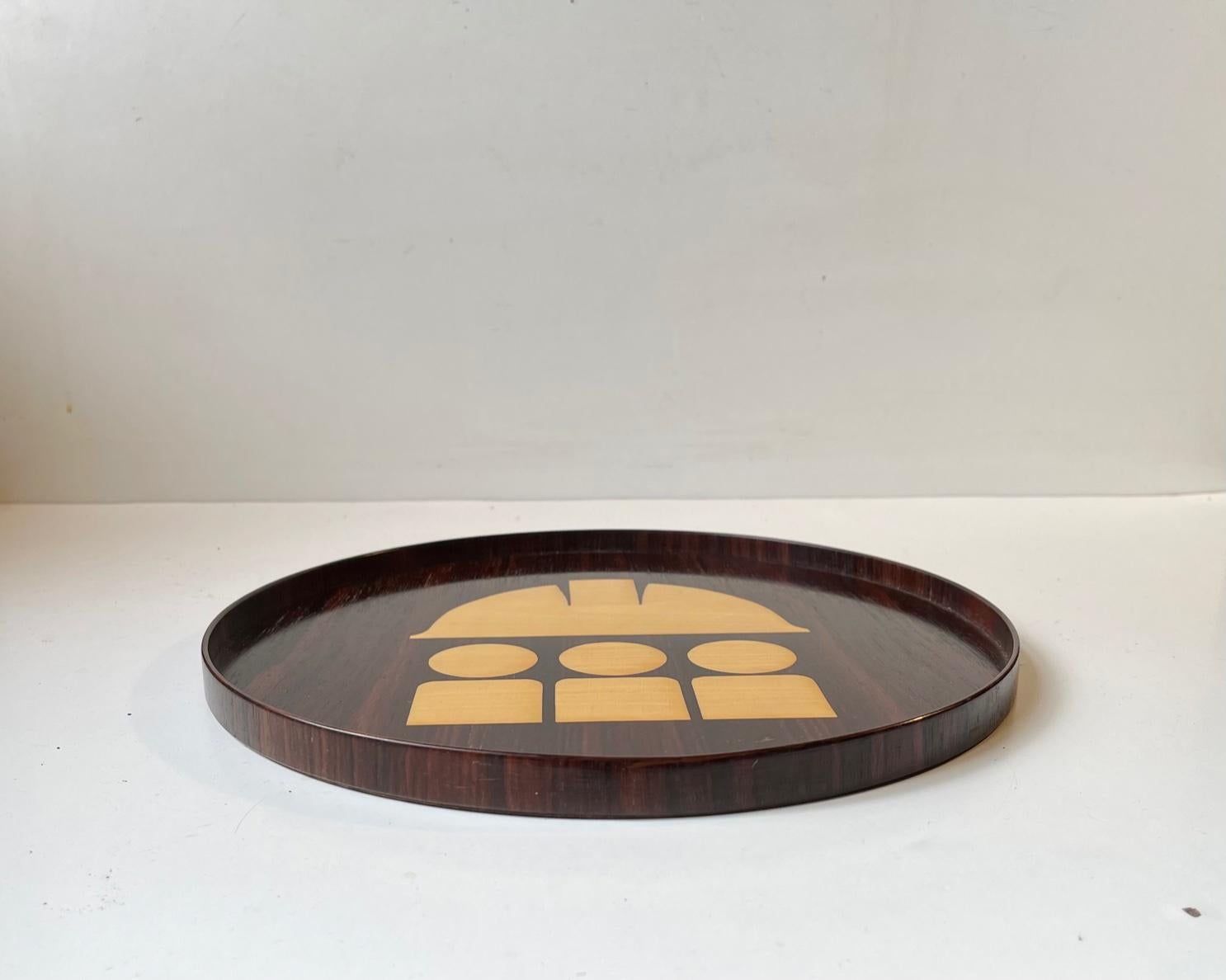 A stylish Scandinavian Modern tray made from flame mahogany and lacquered maple. It made by hand by Intarsia Ring in Denmark circa 1970 in a style reminiscent of Hans Hansen and Alfred Klitgaard. Besides it obvious purpose it can also be hung for