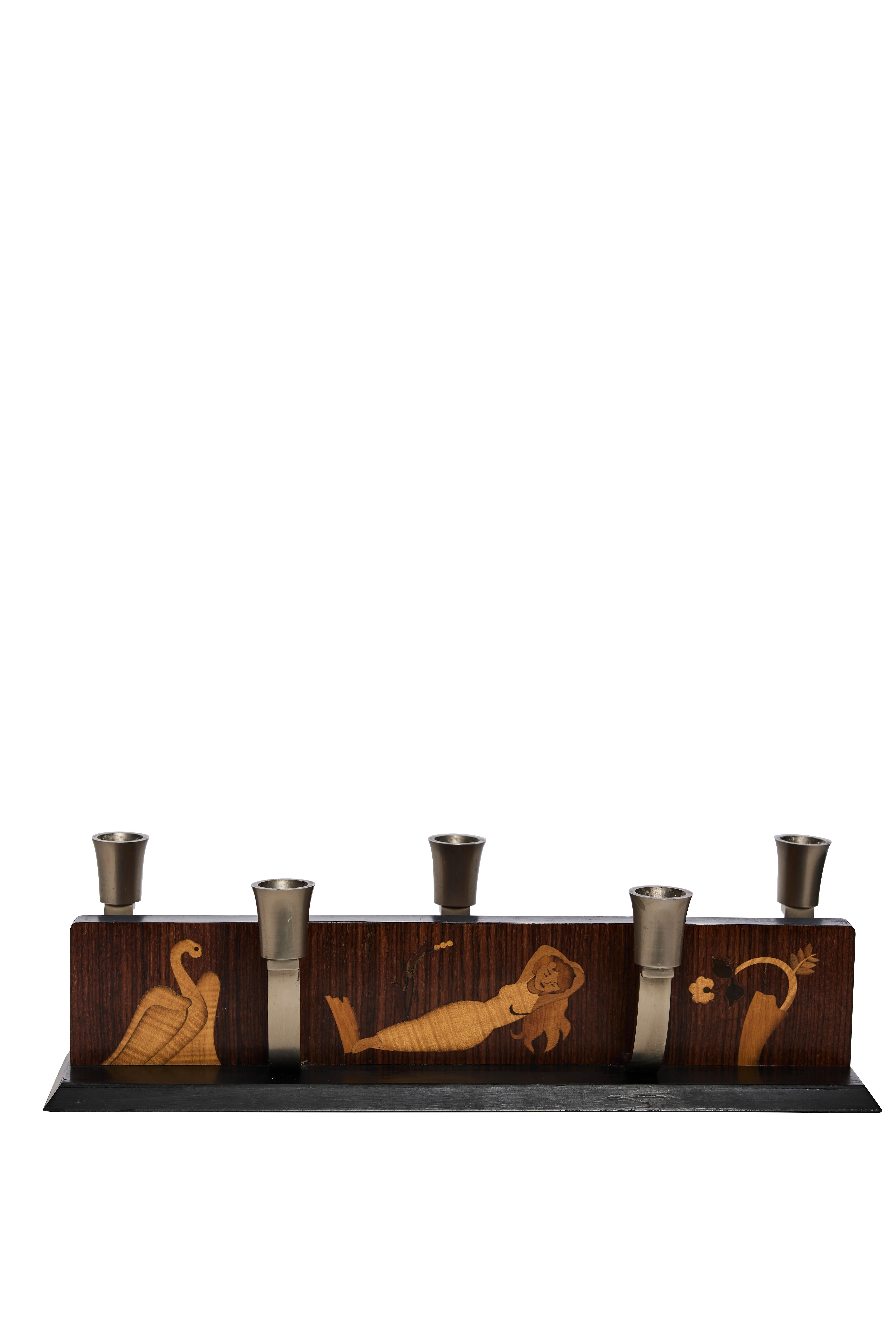 A striking example of Swedish craftsmanship, this Scandinavian Modern “Mjölby Intarsia” Advent candleholder from the 1940s combines artistry, tradition, and functionality. The rectangular wood block features exquisite intarsia inlays depicting