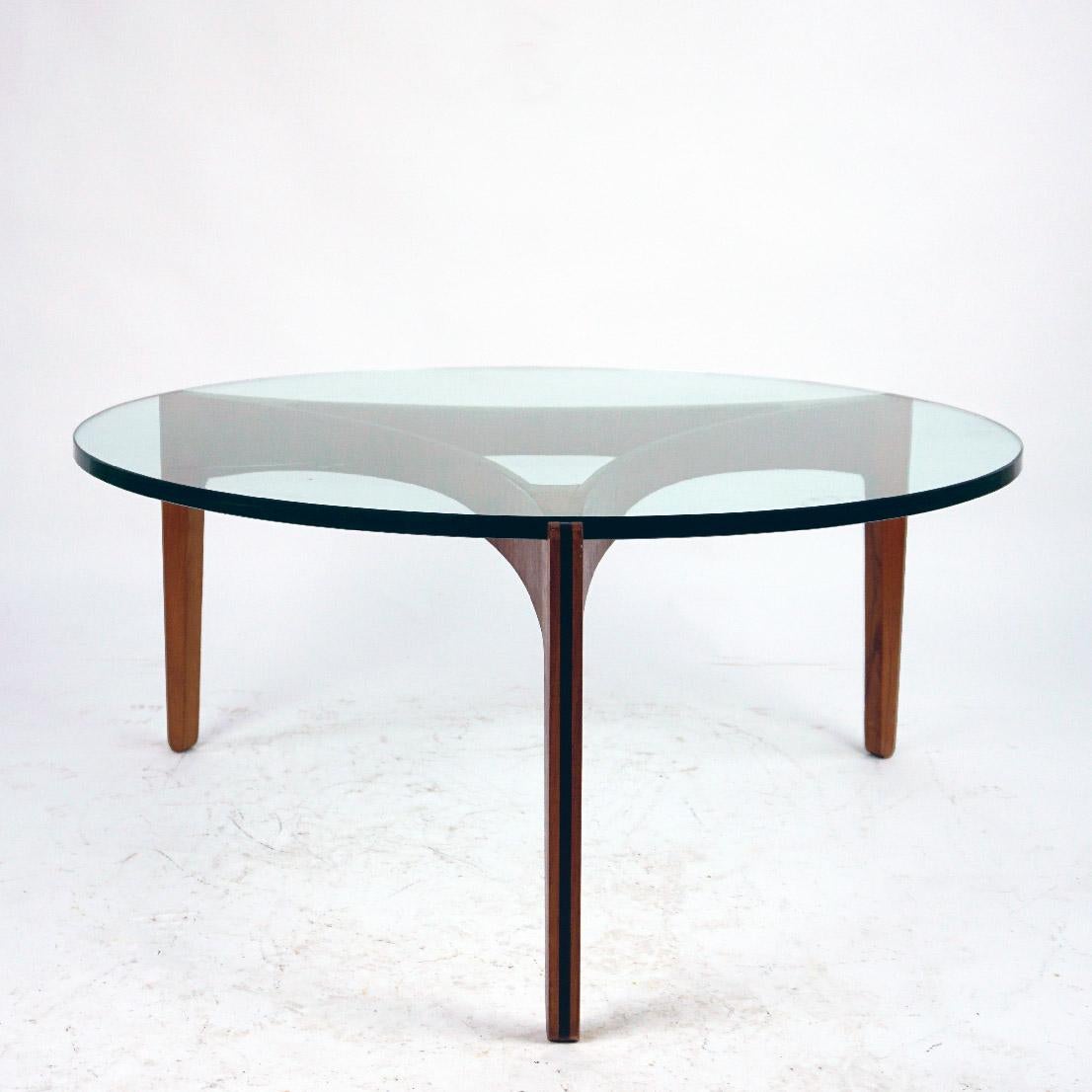 This Stunning circular coffee table model 104 was designed by Sven Ellekaer for Chirstian Linneberg, Denmark 1962. This exquisite coffee table is composed of a beautiful elegant bent teakwood base which supporting a thick transparent glass table
