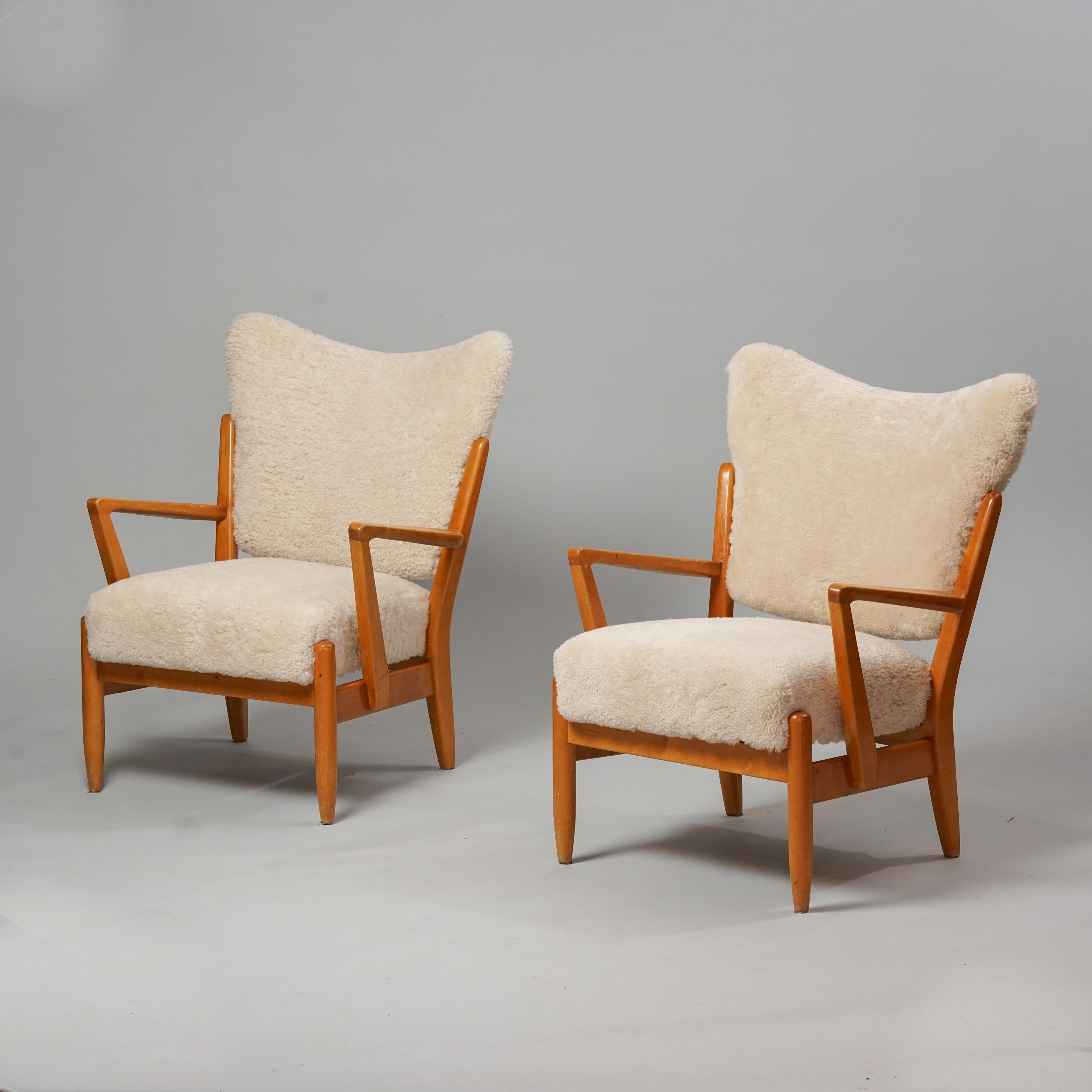 Scandinavian Modern Model 2411 Armchairs, manufactured by Asko, 1950s. Birch frame, new sheepskin upholstery. Good vintage condition, minor patina consistent with age and use. The armchairs are sold as a set. Classic Scandinavian Modern style. 