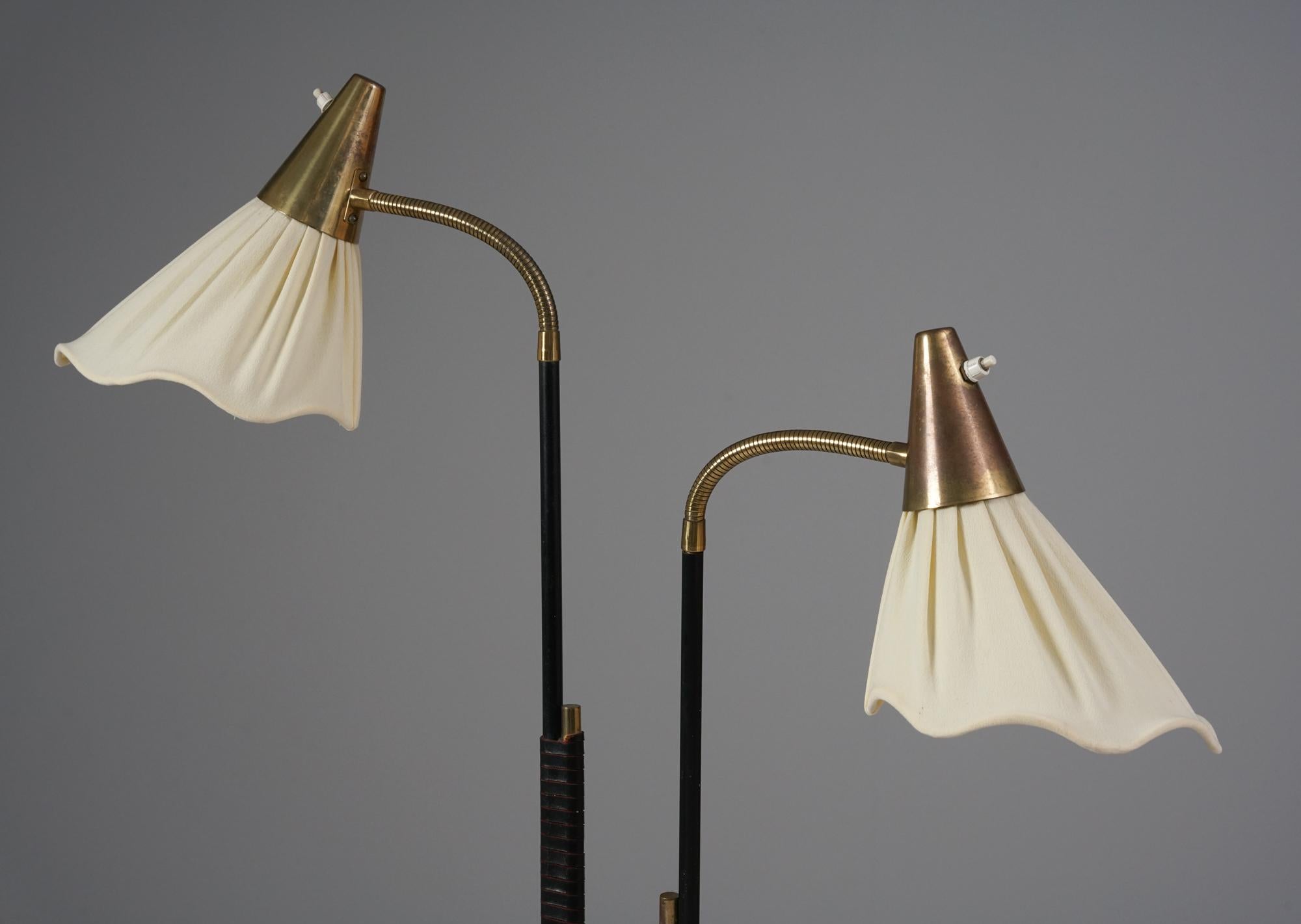 Scandinavian Modern model EN 31 floor lamp, manufactured by Itsu, Finland, 1950s. Brass and painted metal frame, leather wrapping details on the frame, beautiful fabric shades. Good vintage condition, minor patina consistent with age and use. 