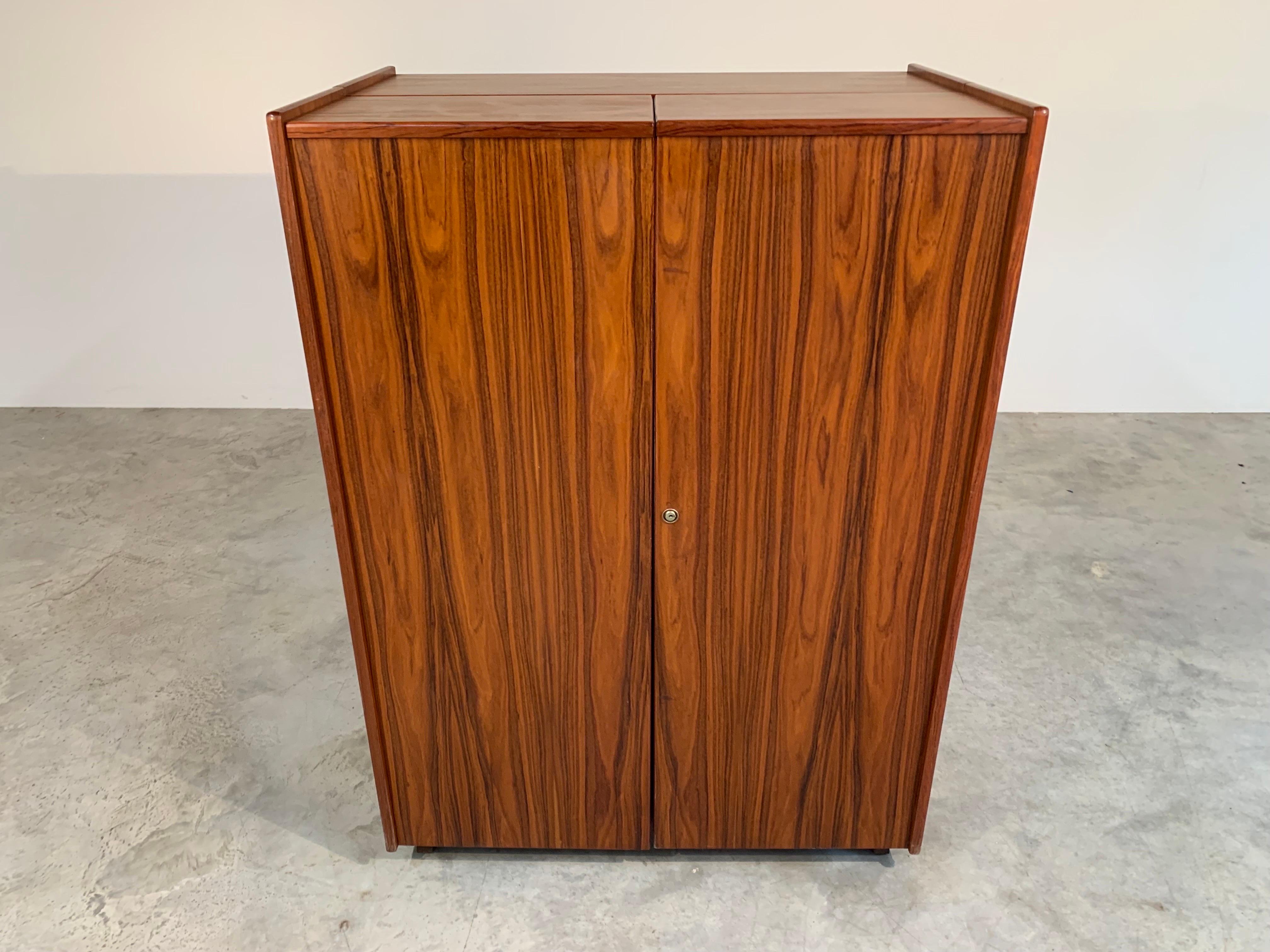 This “magic box” folding desk was originally designed in 1928 by Swiss architects Mummenthaler and Meier. 
 The desk opens up to reveal several storage cubbies along with a rosewood desk surface that opens up to 55.25” Wide and 18.75” Deep. Over
