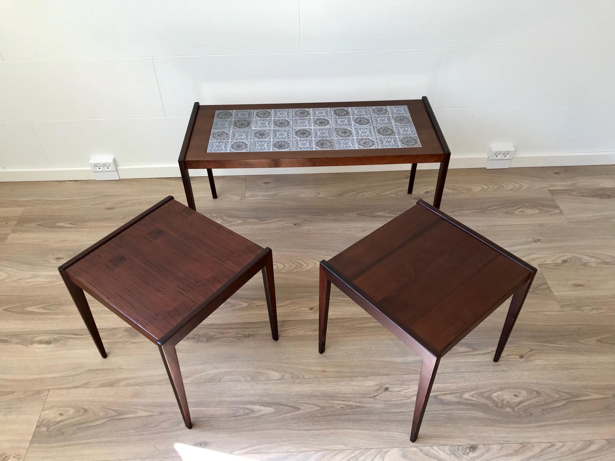 A nest of tables fashioned from teak and dark oak. The rectangular main table has inlaid tiles from Royal Copenhagen. Very practical if used as a coffee table group since the tiles allows wet and hot drinks etc. being served without any protection.