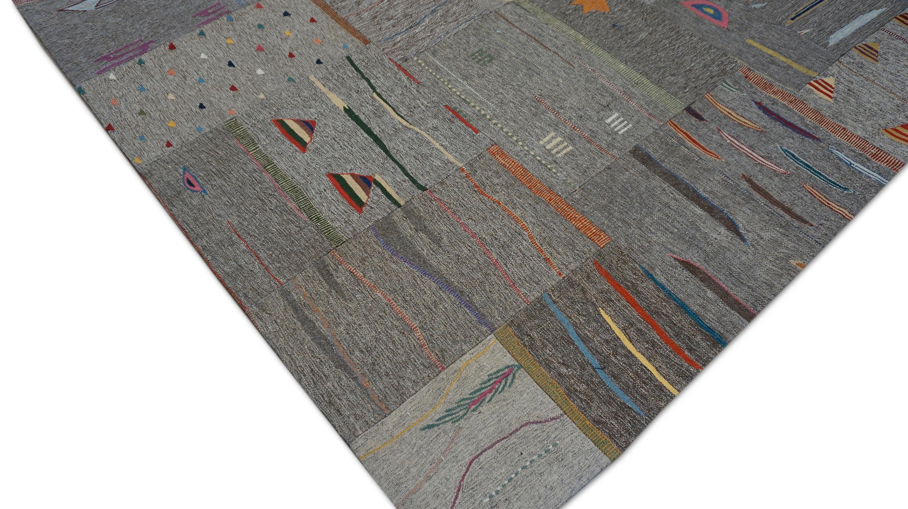 Dieser moderne, handgewebte Wollteppich zeigt eine kühne, abstrakte Patchwork-Komposition, die von Stammes- und Nomadenmotiven inspiriert ist. Der Teppich wird aus handgesponnener Wolle und mit traditionellen Knüpftechniken hergestellt, wobei das
