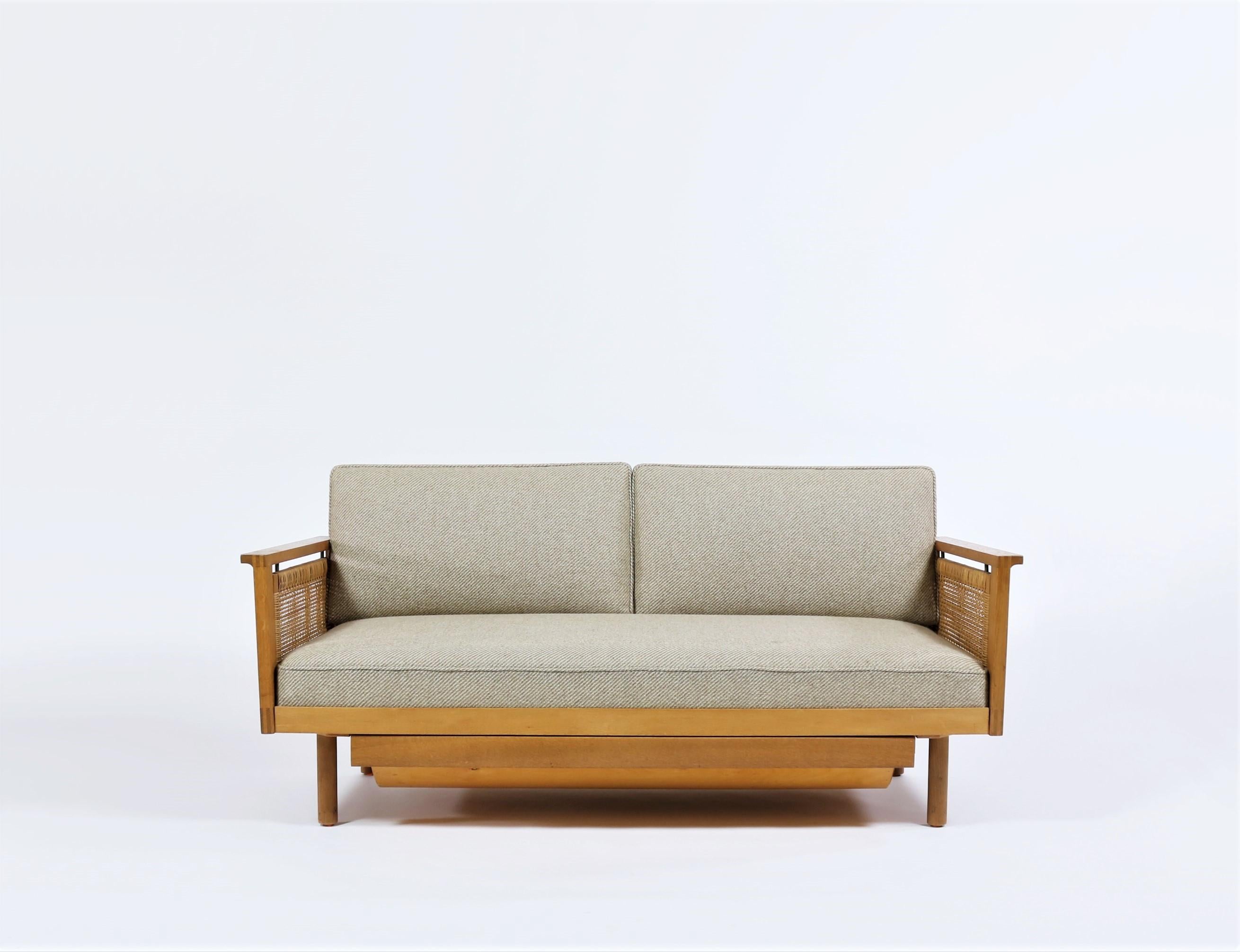 Charming daybed by Danish architect Illum Wikkelsøe made at cabinetmaker N. Eilersen in the 1950s. The bed is made from solid oak and features beautiful hand crafted details. The daybed has fold-down cane sides that can be adjusted to three