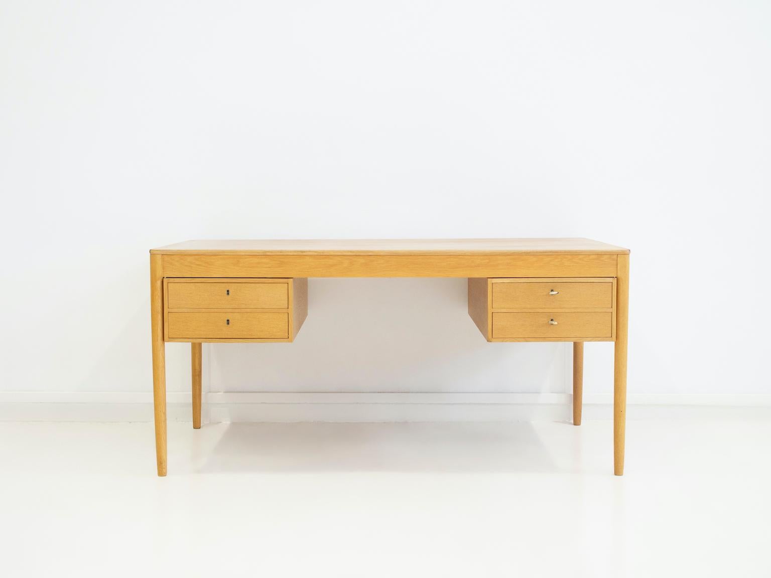 Oak desk designed by Yngvar Sandström and manufactured by AB Seffle Möbelfabrik in Sweden. The desk features two drawers on both sides that can be easily removed. Keys included. Stamped by maker underneath.