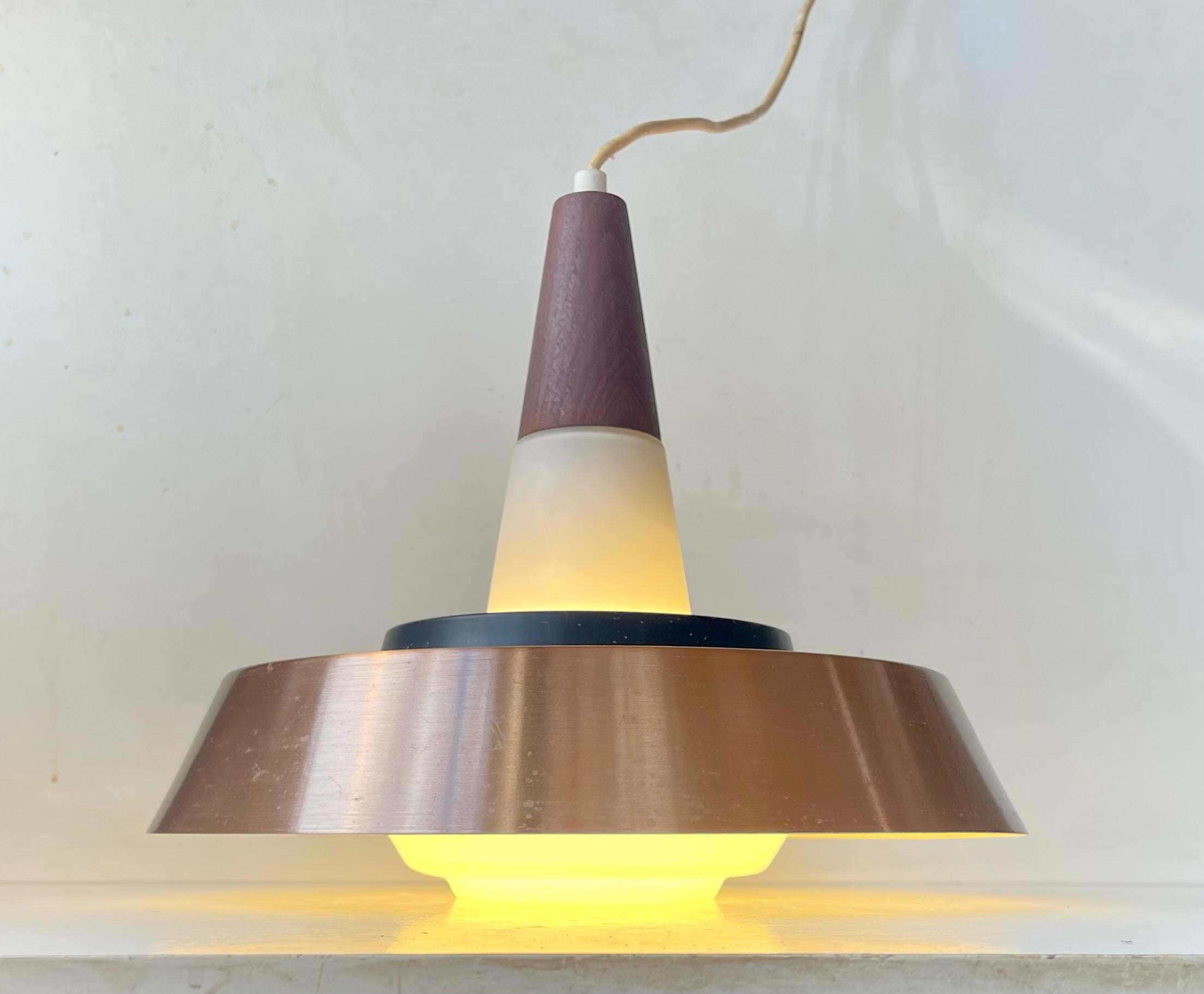 Elegant ballerina shaped ceiling lamp. Its made from hand-blown opaline glass from Holmegaard set with a large copper alloy shade and a smaller contrasting black one. The top is made from solid engine-turned teak. Designed by Ernest Voss in the 50s