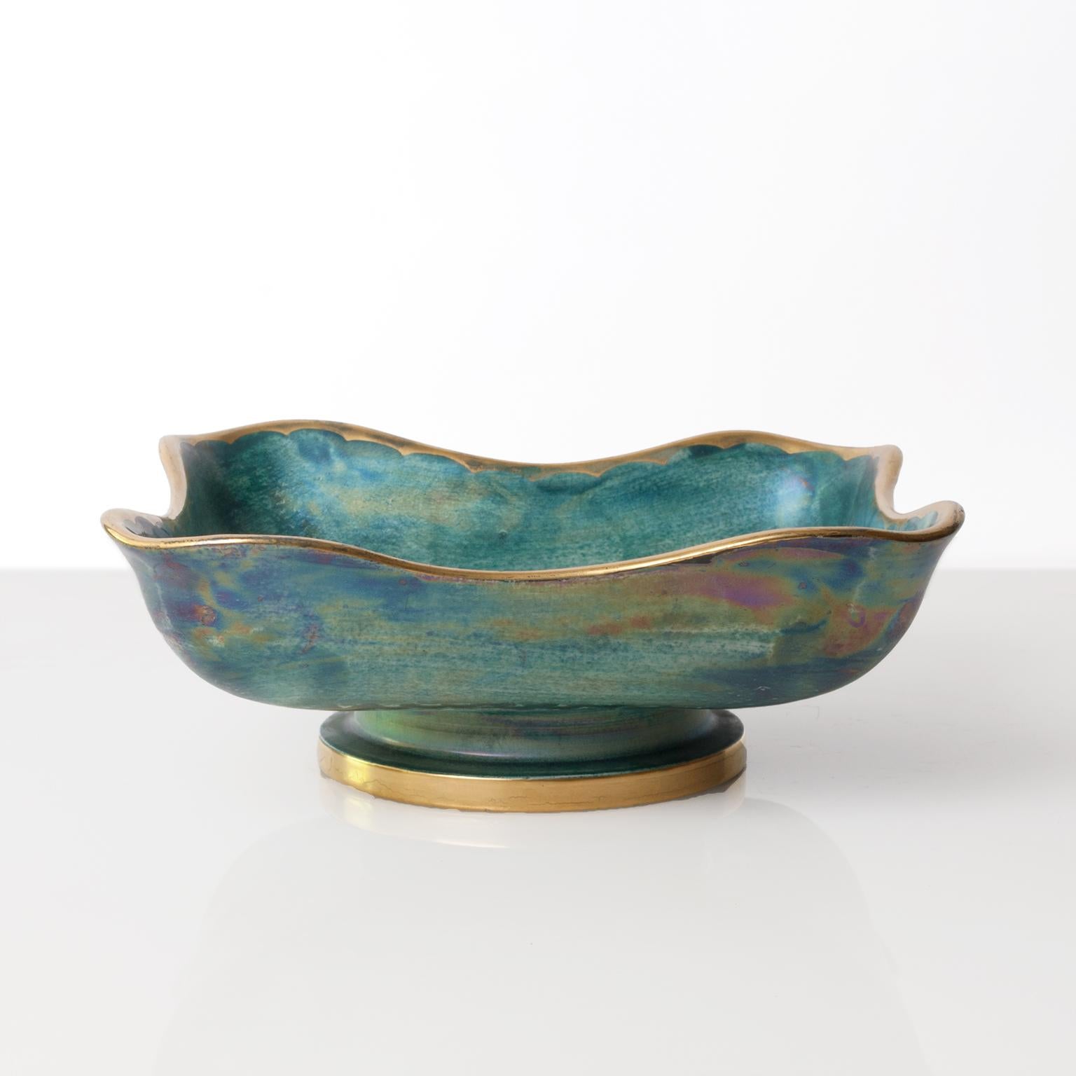 Scandinavian Modern ceramic bowl with a soft organic form with a luster glaze in blue and green and a hand-painted floral design and trim in gold. Designed by Josef Ekberg for Gustavsberg, Sweden, signed and dated 1936.
 
Measures: Height 3.25