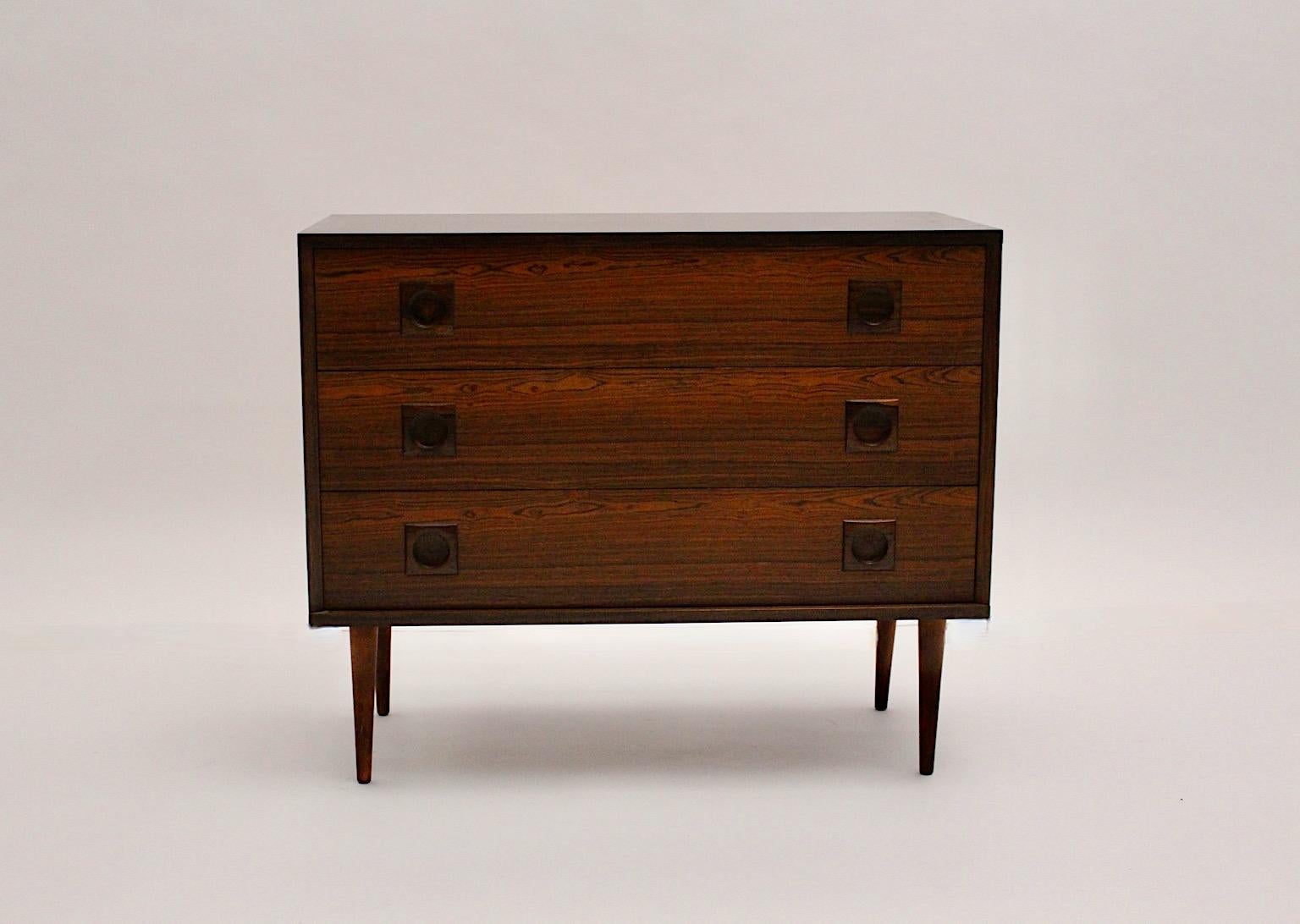 Scandinavian Modern organic vintage chest of drawers or commodes from teak designed and manufactured, 1960s, Denmark.
An amazing chest with three (3) drawers and much storage space shows a beautiful wood veneer in brown and dark brown color
