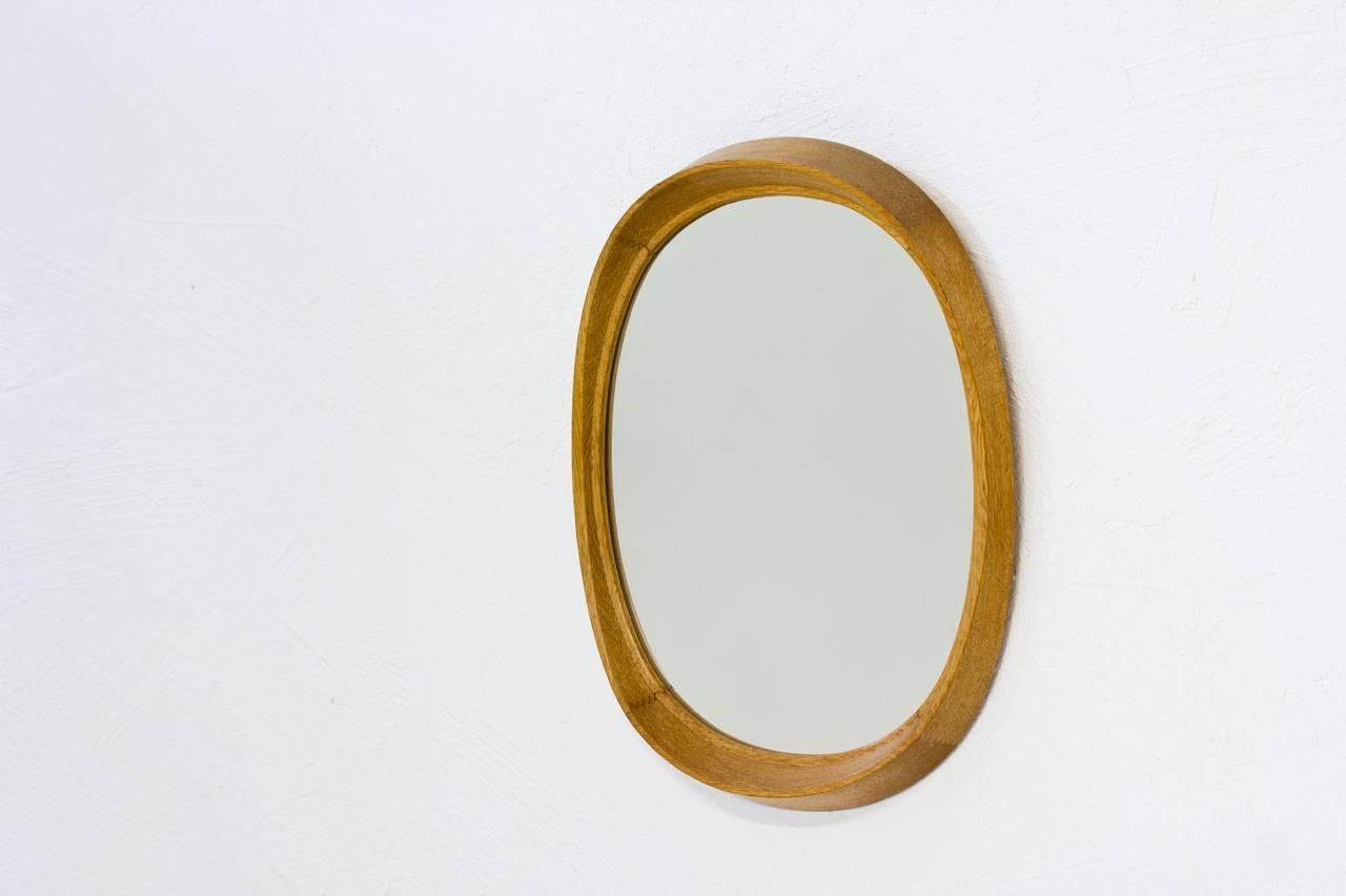 Oval shaped oak wall mirror manufactured by Fröseke, AB Nybrofabriken during the 1950s in Sweden. Oak frame with nice curves and joinery details. Labeled in the back, model “Camilla” 650.