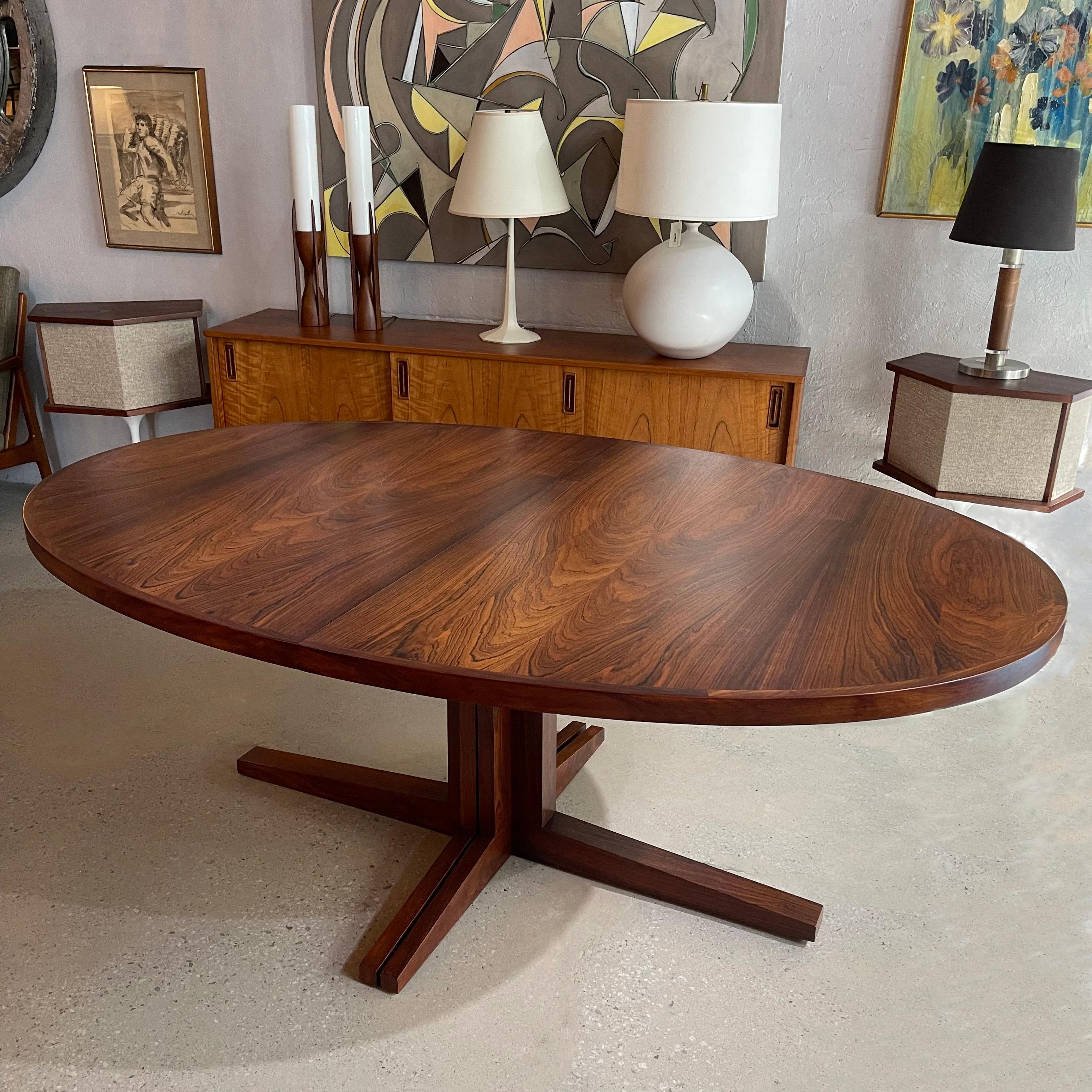 Spectacular, Danish modern, rosewood, extension dining table designed by John Mortensen for Heltborg Møbler features a 1.5 inch thick, oval top with faceted pedestal base. The table top has an exceptional rosewood grain with contrasting trim. The