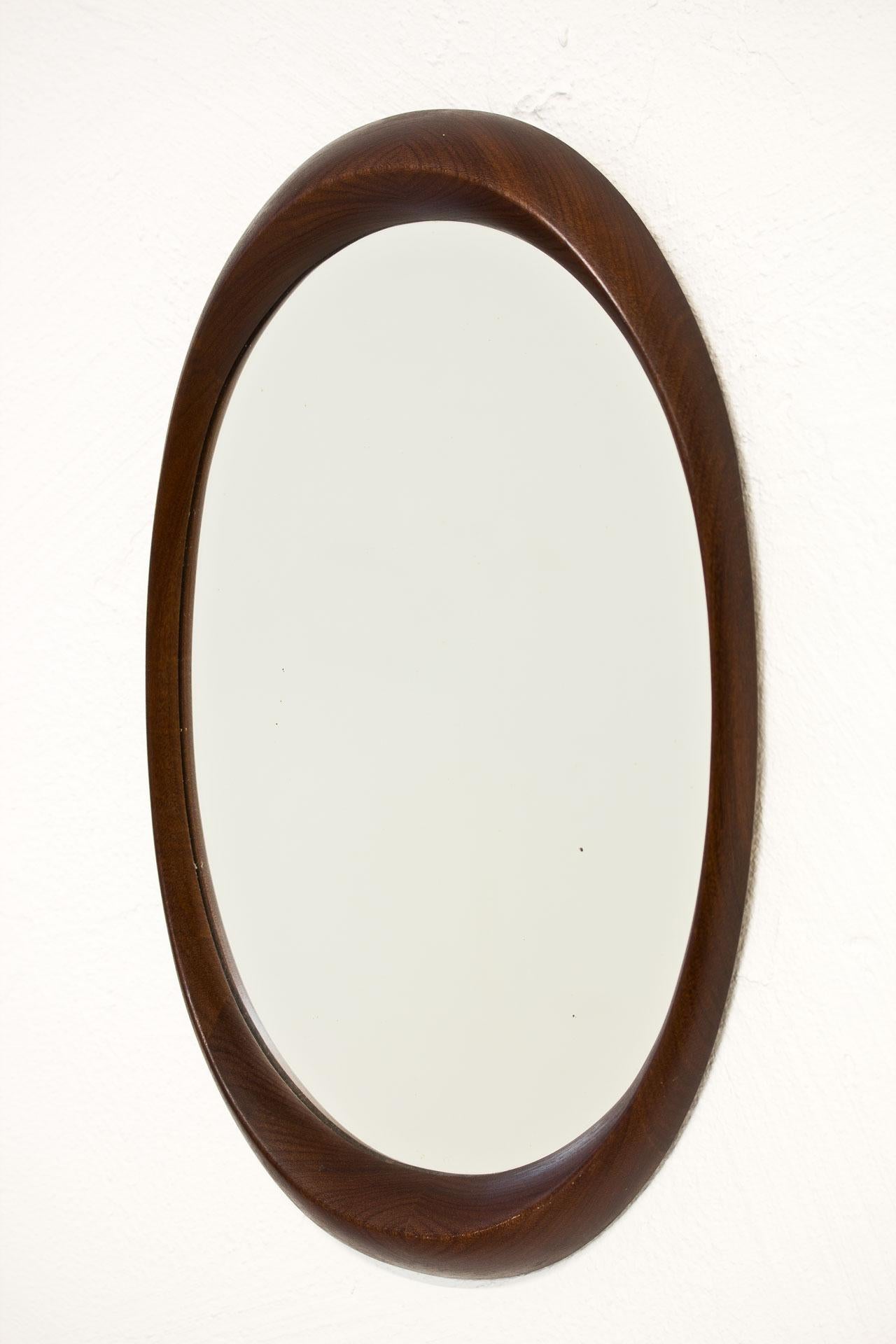 Oval shaped wall mirror from unknown maker. Made in Sweden during the 1960s. Frame in Afromosia (African wood) with nice curves and joinery.
 