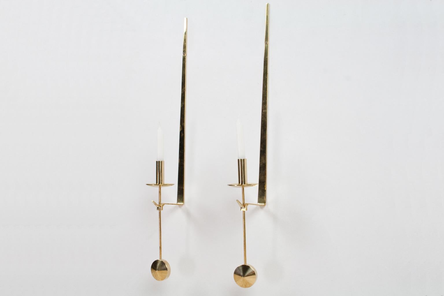 Pair of elegant Scandinavian Modern brass 'Pendeln' wall-mounted candleholders by Pierre Forssell, design later part of the 1950s. Brand present. The set is in good vintage condition. Originated from Sweden 1960s-1970s. For the Pendel holder use