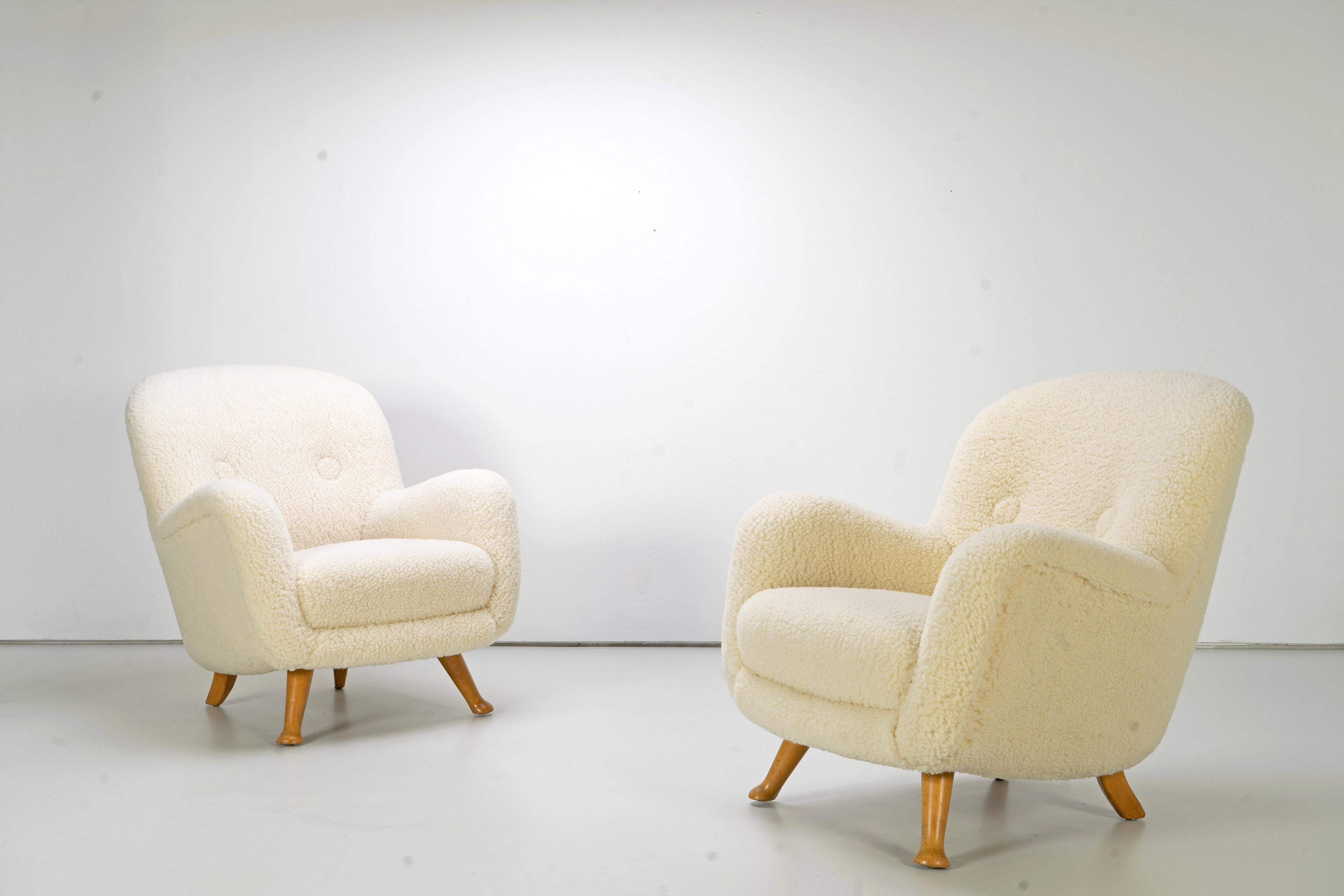 Beautiful pair of Scandinavian Modern club/lounge chairs with organic features and a humorous twist by Berga Møbler. The chairs have been newly upholstered.