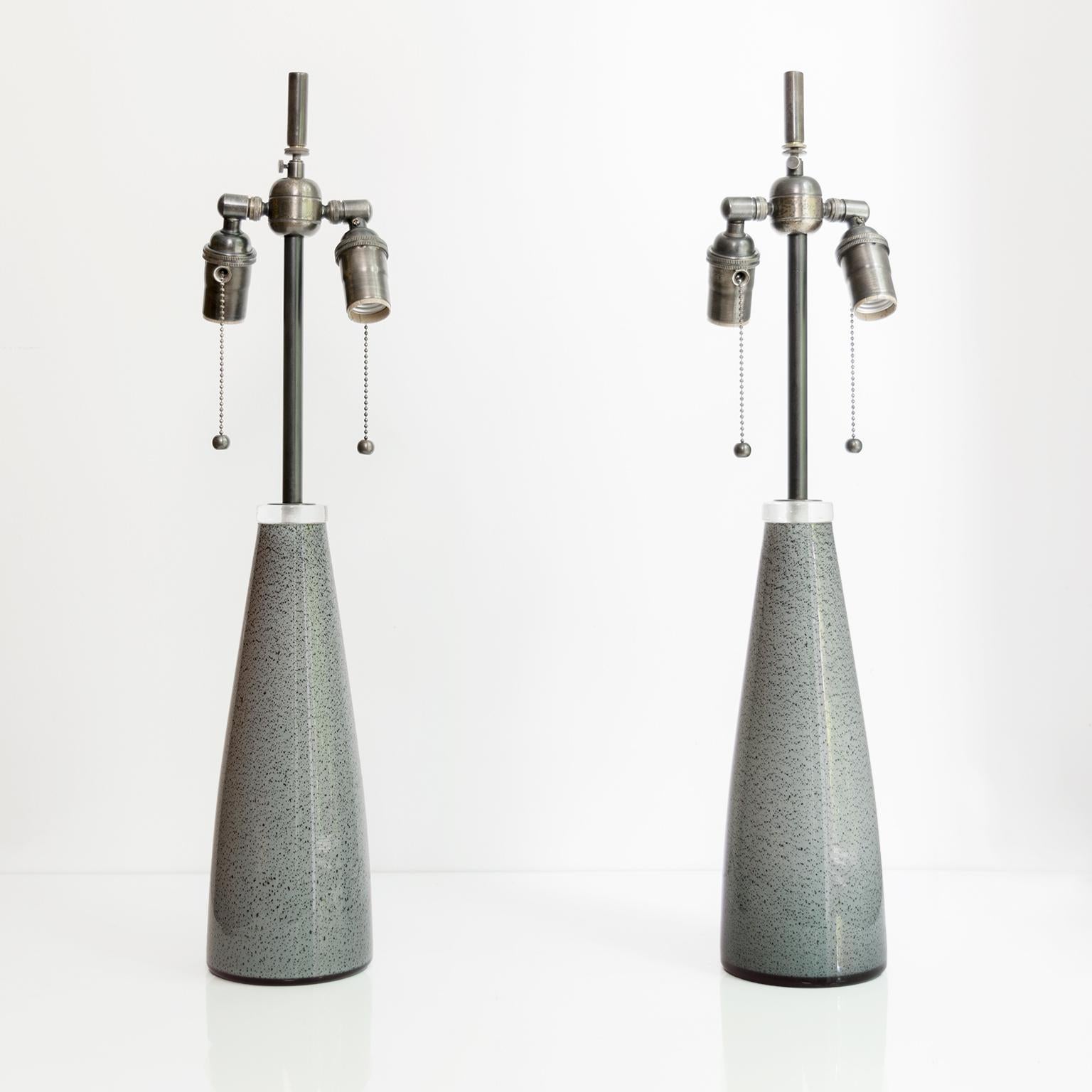 Sleek pair of Scandinavian Modern, Swedish speckled glass lamps made by Johansfors Glasbruk circa 1960’s. The lamps have new custom hand patinated steel hardware including double socket clusters and wired for use in the USA. 
Measures: Height 25”,