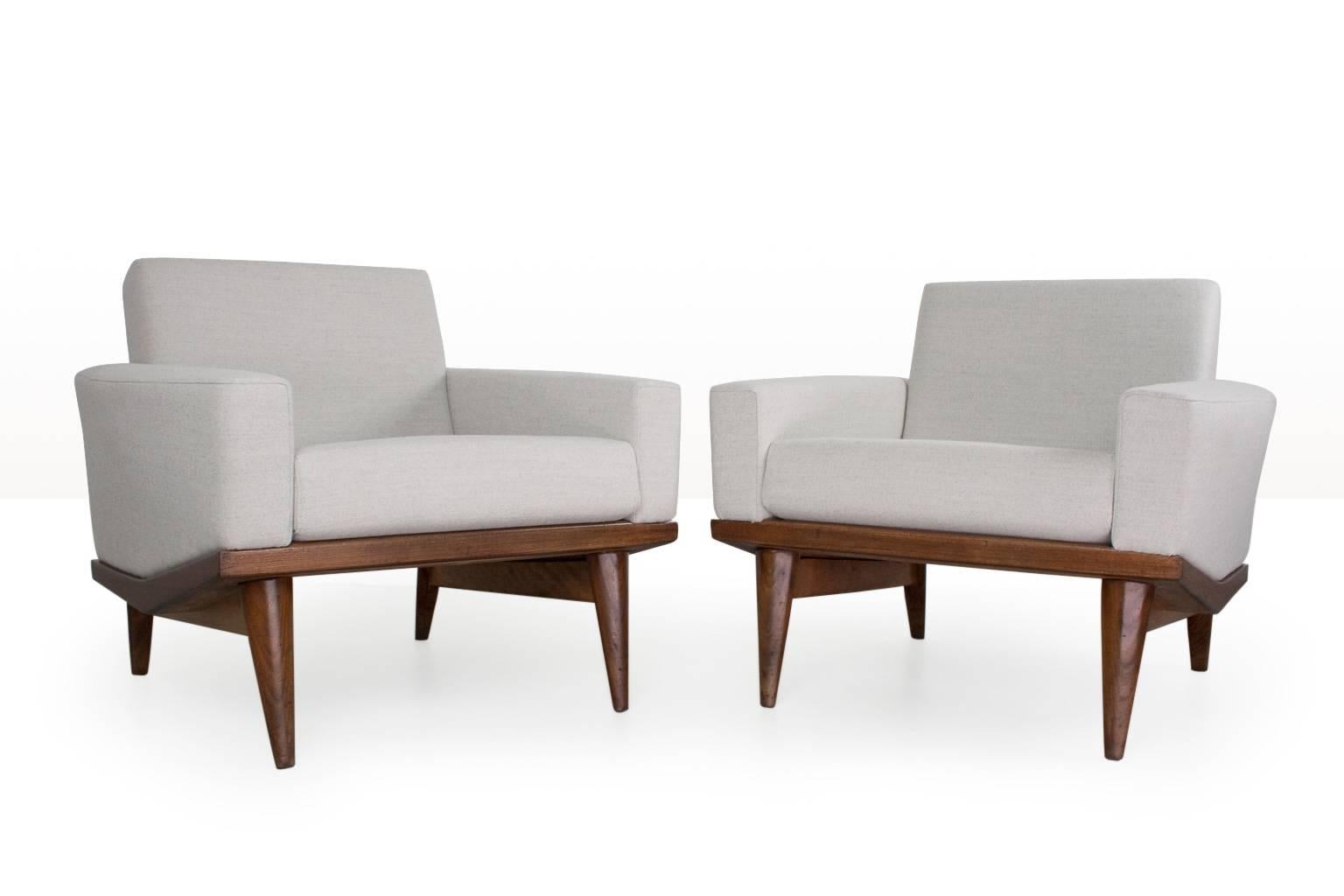 Pair of Illum WIkkelso lounge chairs, new upholstered in a excellent quality light grey Ploegwool (no.98) on a teak wooden frame. In excellent condition. The design is often referred to as the 'Australia' design. The sharp finishes of the