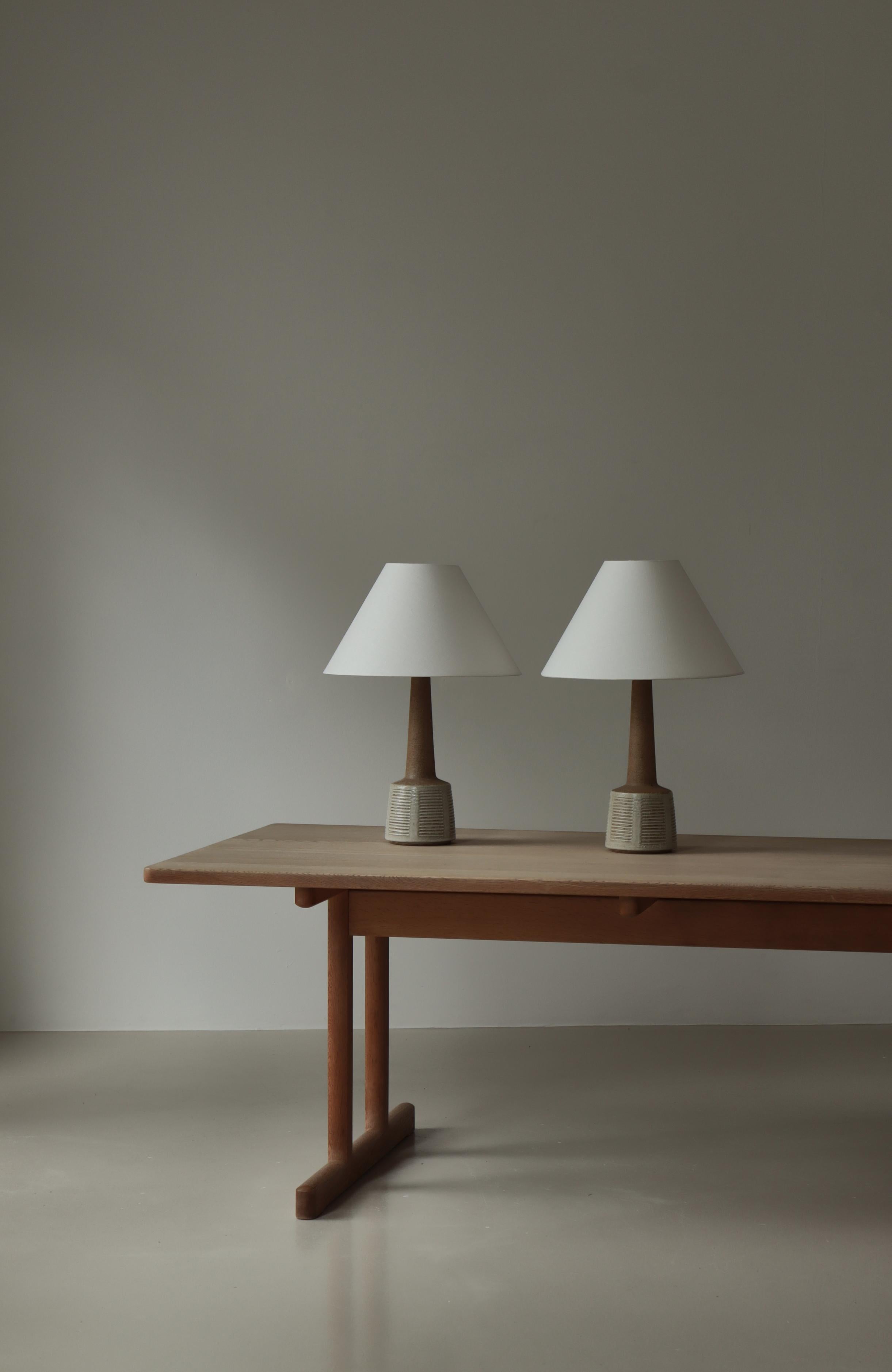 Bellissima coppia di lampade da tavolo vintage in gres realizzate negli anni '60 presso il laboratorio di gres Palshus in Danimarca. Design di Esben Klint. Realizzato in gres chamotte con una leggera smaltatura e decorazioni in rilievo. Entrambe le
