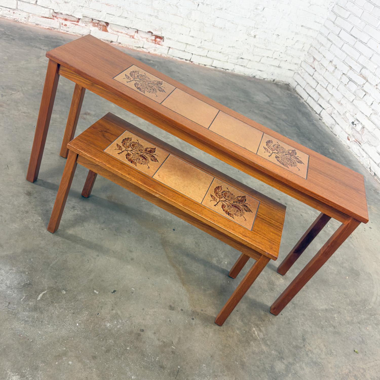 Gorgeous Late-20th Century Scandinavian Modern pair of teak nesting sofa or console tables with tile insert tops marked Made in Denmark. Beautiful condition, keeping in mind that these are vintage and not new so will have signs of use and wear even